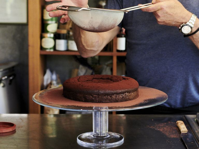 Schritt 6: Glutenfreier Schokoladen-Haselnuss-Kuchen mit Kakaopulver bestreuen.