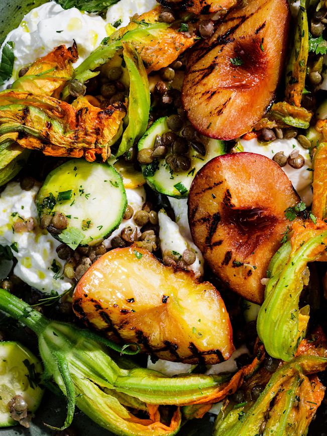 Close-up des Linsensalat mit grillierten Pfirsichen, Zuchiniblüten und Stracciatella Close-up des Linsensalat mit grillierten Pfirsichen, Zuchiniblüten und Stracciatella