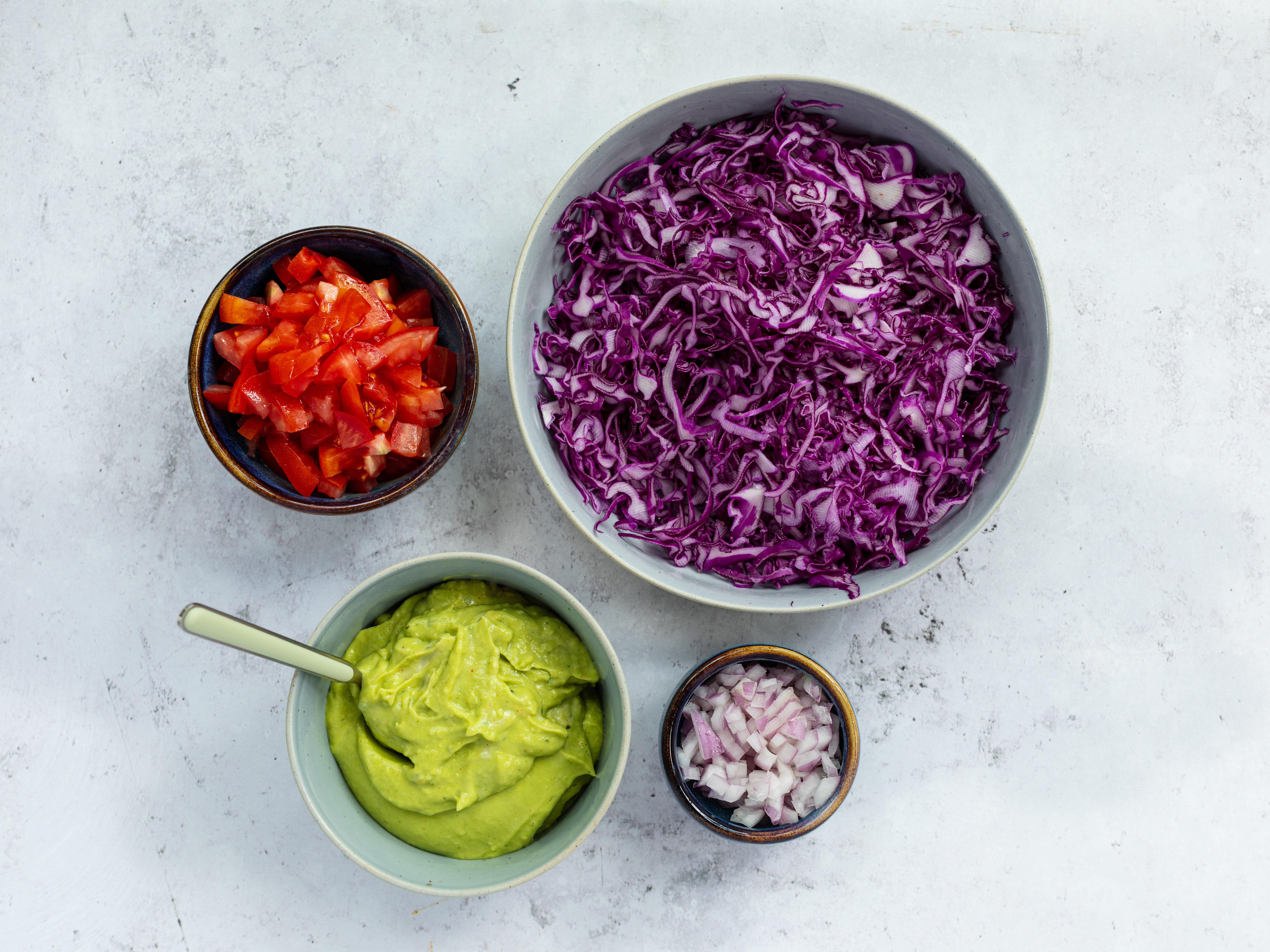 Schritt 3: Die Zwiebel schälen und fein hacken, Tomaten waschen und in Würfel schneiden. Den Rotkohl mit einer Mandoline oder einem scharfen Messer in feine Streifen schneiden. Die Bohnen abtropfen