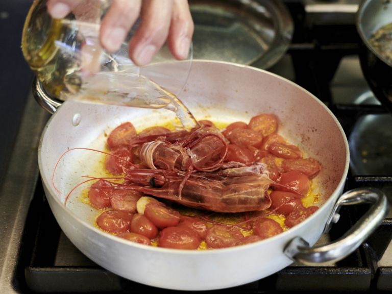 Schritt 1: Die Tomatenhälften in Olivenöl zusammen mit der Knoblauchzehe und den Schalen und Köpfen der Gamberi sanft zugedeckt 