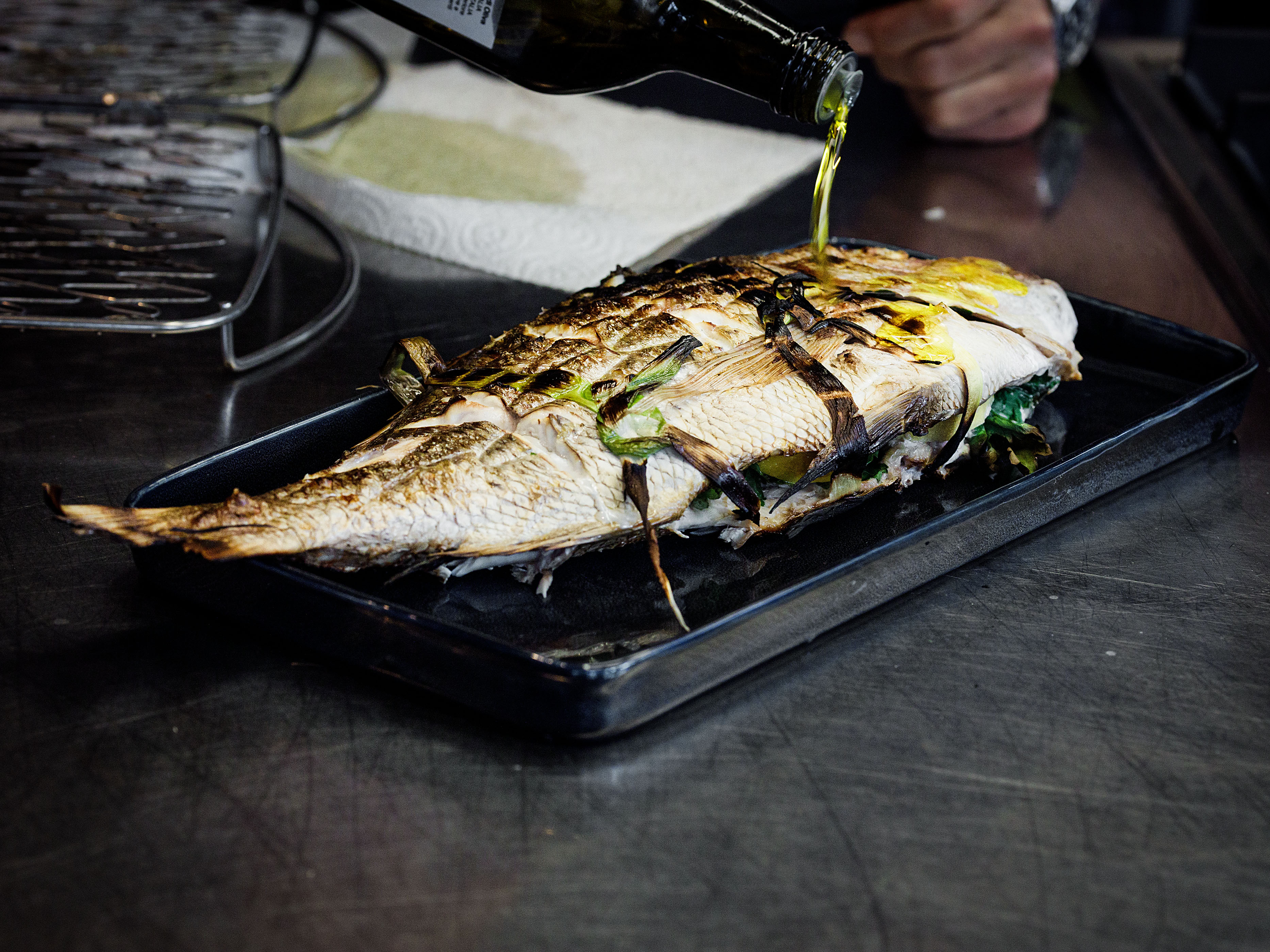 Schritt 3: Den fertig gegarten Fisch mit Olivenöl würzen