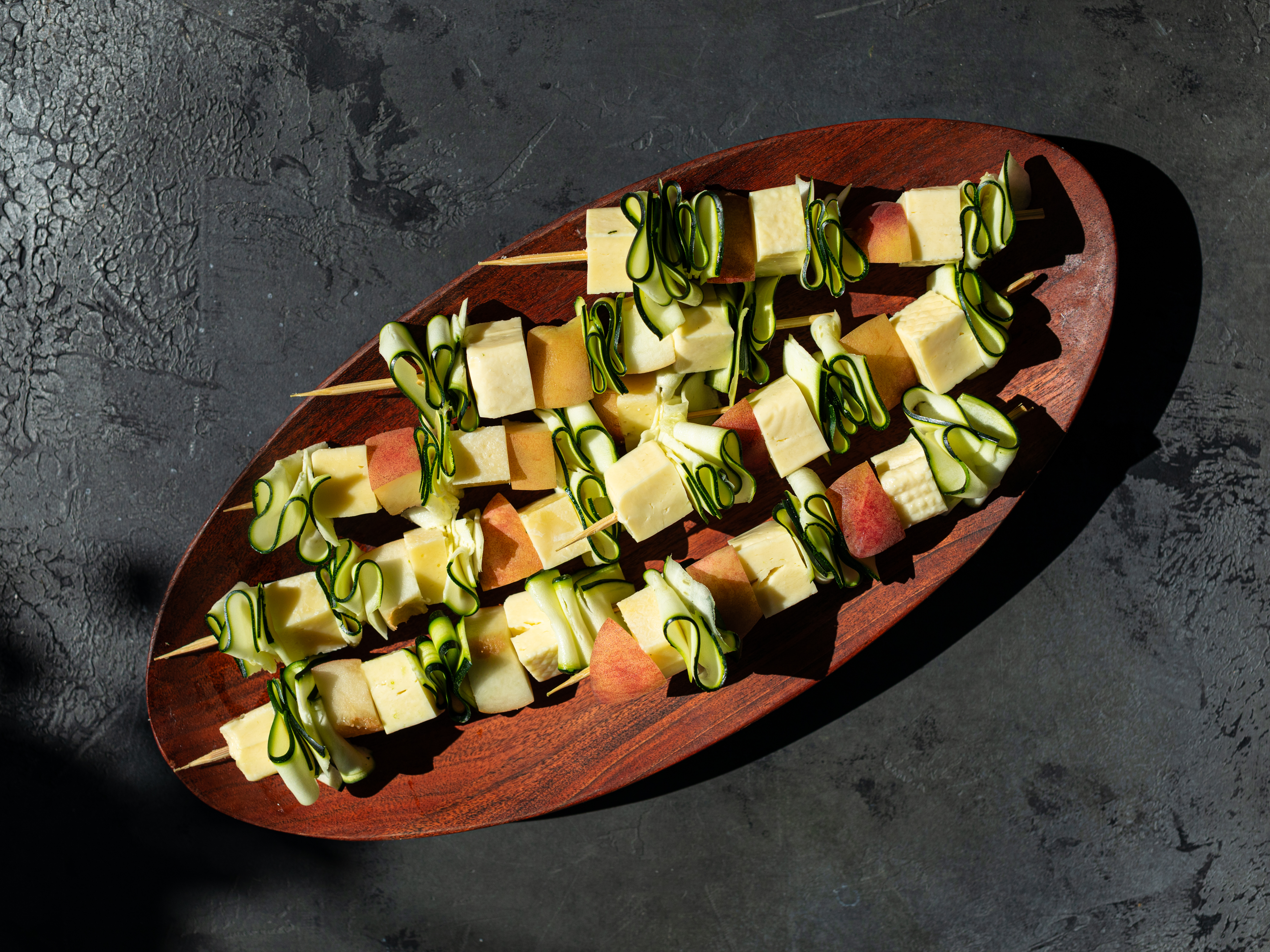 Schritt 1: Die Zucchetti, Pfirsiche und Haloumi-Würfel abwechselnd auf die Holzspiesse stecken