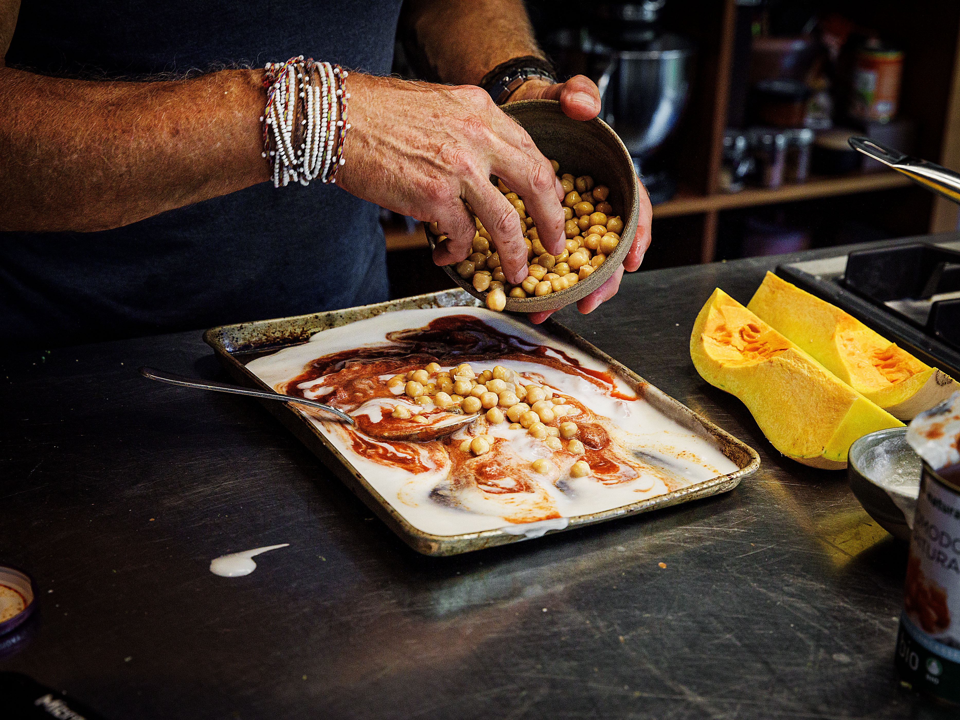 Schritt 1: Currypaste, Kokosmilch, Butternusskürbis, Tomaten und Kichererbsen auf einem Backblech vermengen