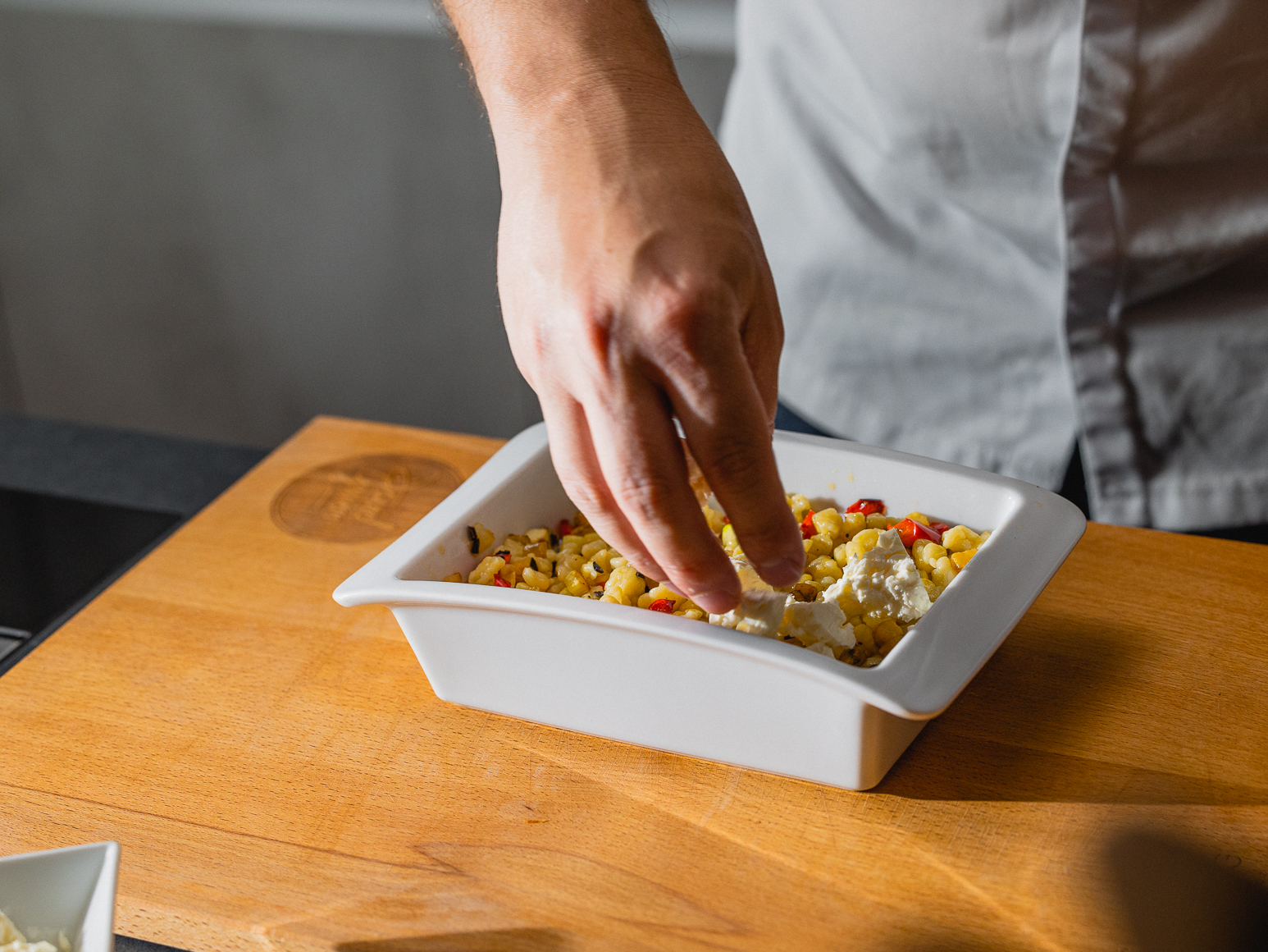 Schritt 2: Mit Salz und Pfeffer abschmecken und anschliessend in eine Auflaufform geben und den Feta in kleine Würfel schneiden und über die Spätzle streuen.  