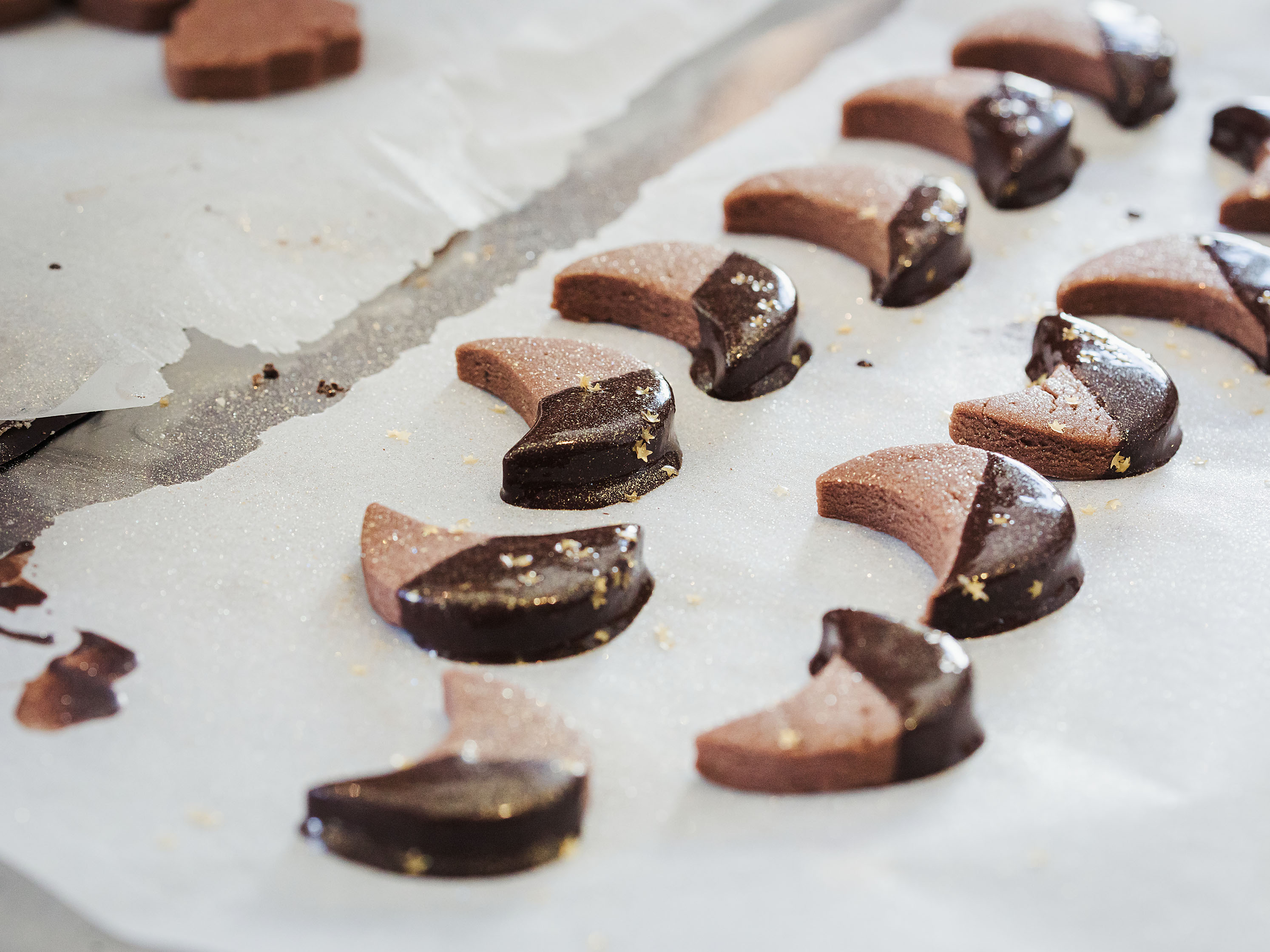 Schritt 3: Die Sablés glasieren und sofort, bevor die Schokolade fest wird, mit Zuckerperlen oder Zuckersternen dekorieren