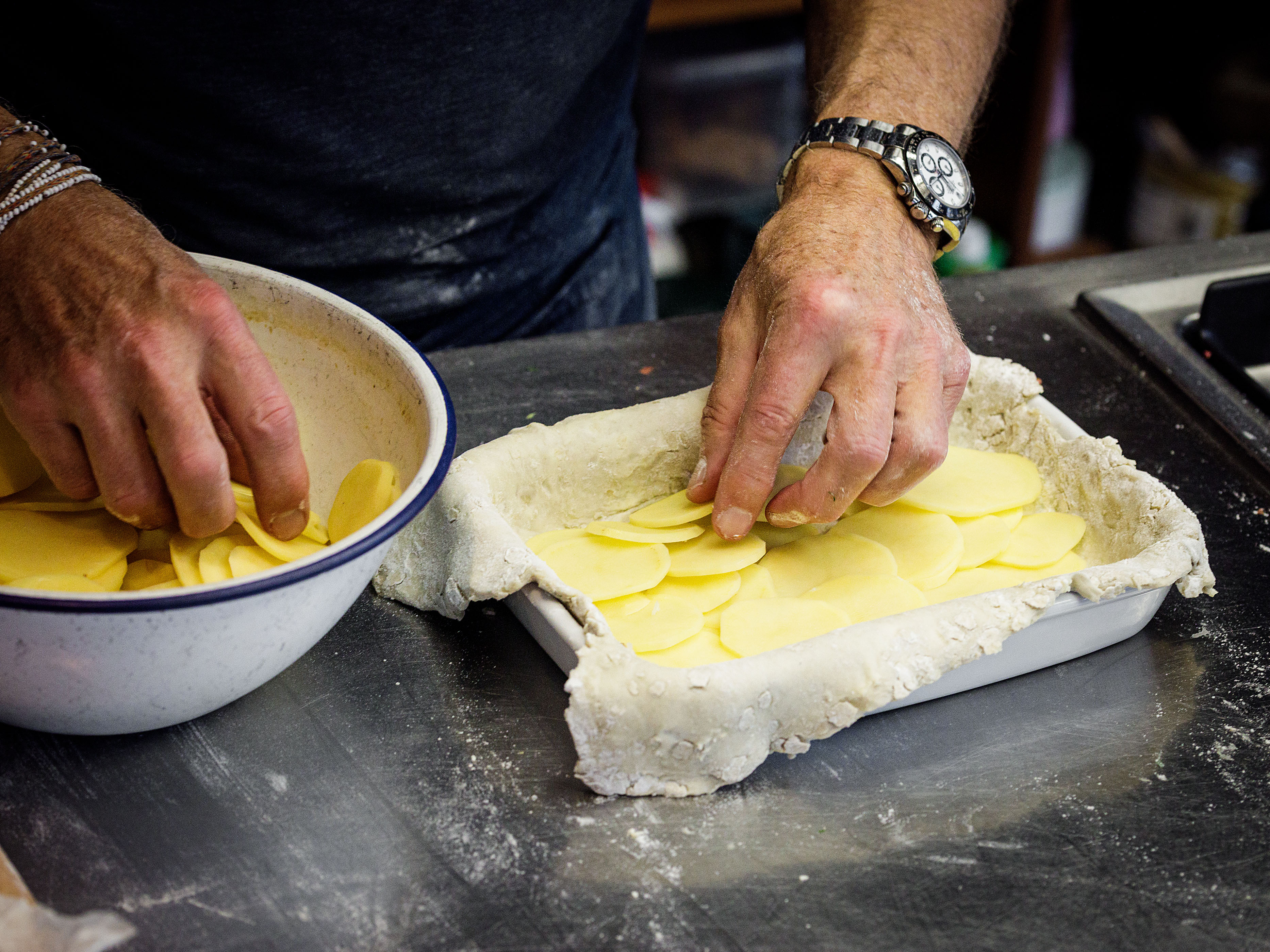 Schritt 3: Ein Drittel der Kartoffelscheiben auf dem Teig verteilen