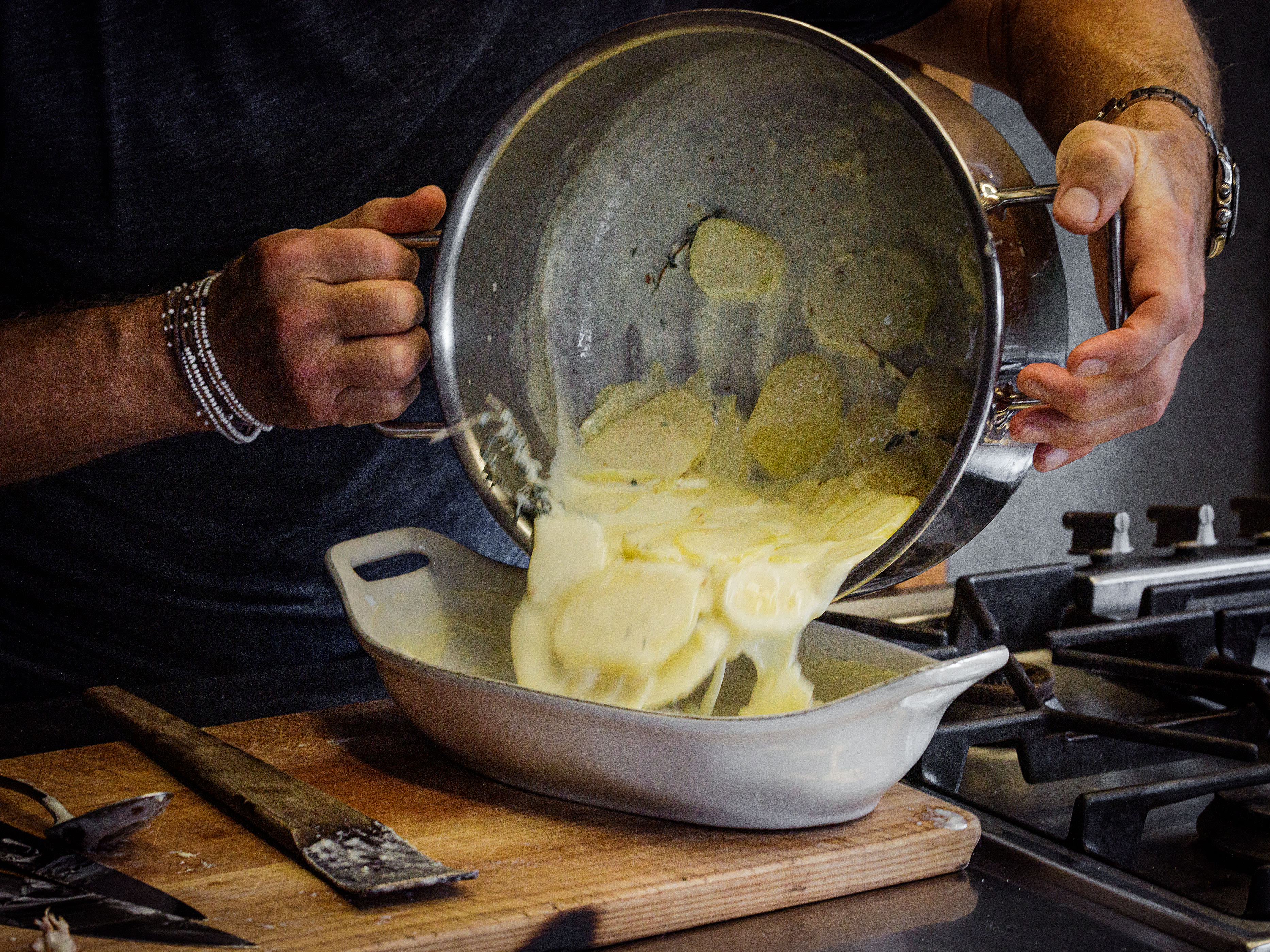 Schritt 2: Eine weite, feuerfeste Form ausbuttern und die Kartoffelscheiben zusammen mit der Rahm-Milch-Sauce möglichst flach einschichten;