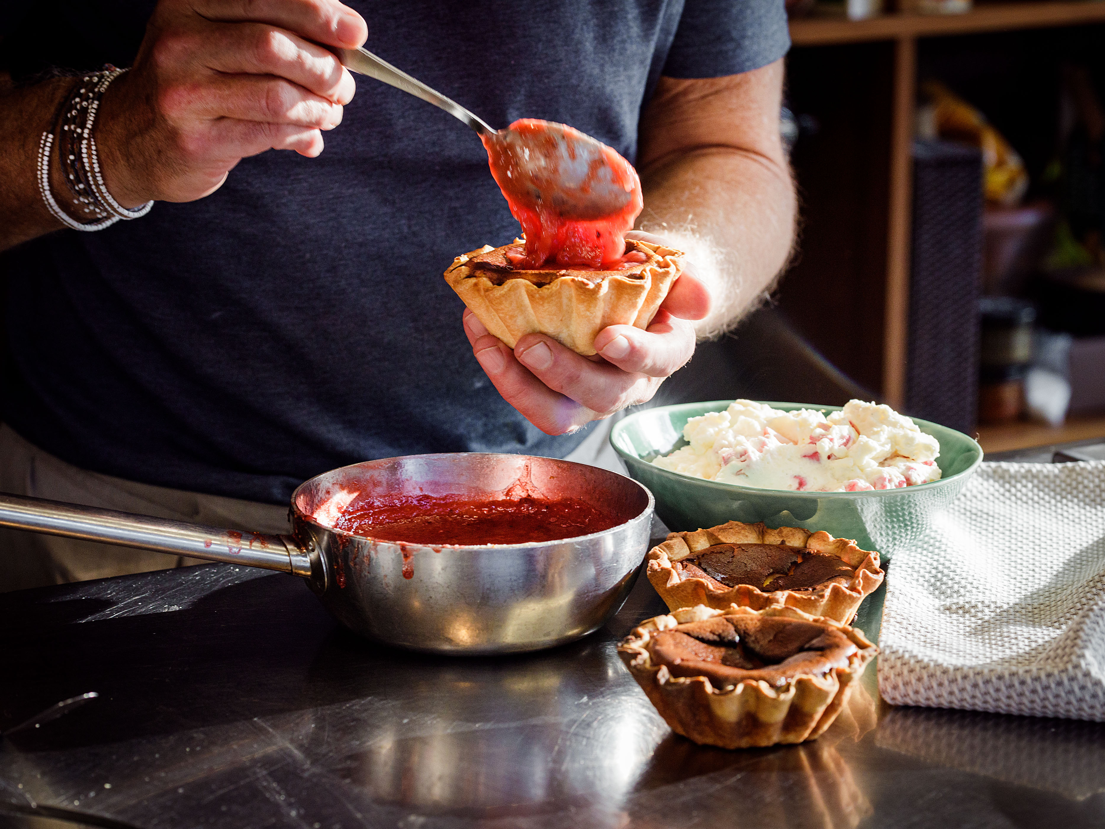 Schritt 5: Erdbeersauce auf die vier Mini-Cheesecakes verteilen, darüber den Rhabarber-Rahm auftürmen