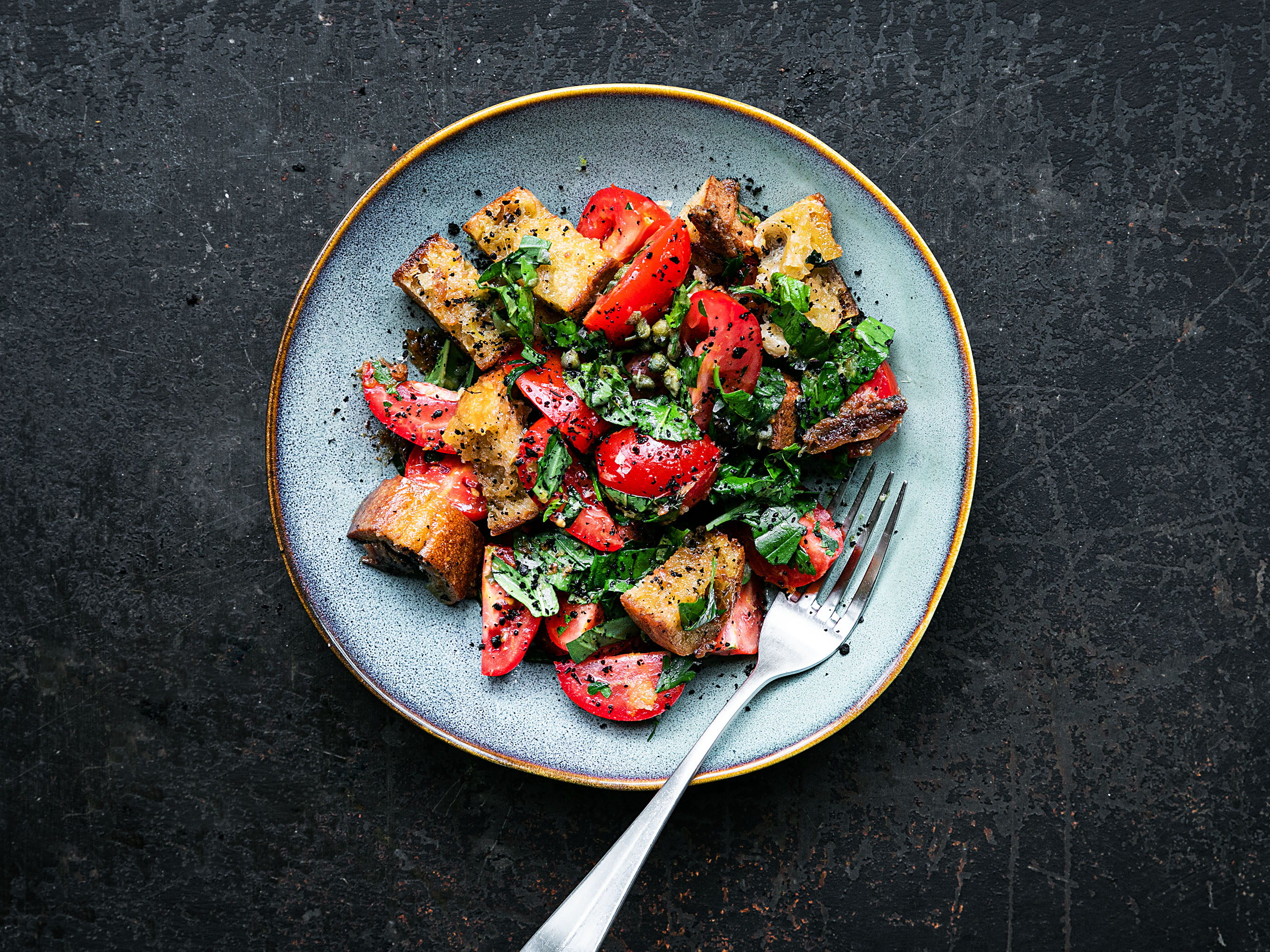 Schritt 3: Den Salat auf Teller verteilen, mit dem Sardellen-Knoblauch-Öl beträufeln, die restlichen Kräuter und die Chiliflocken darüber streuen.