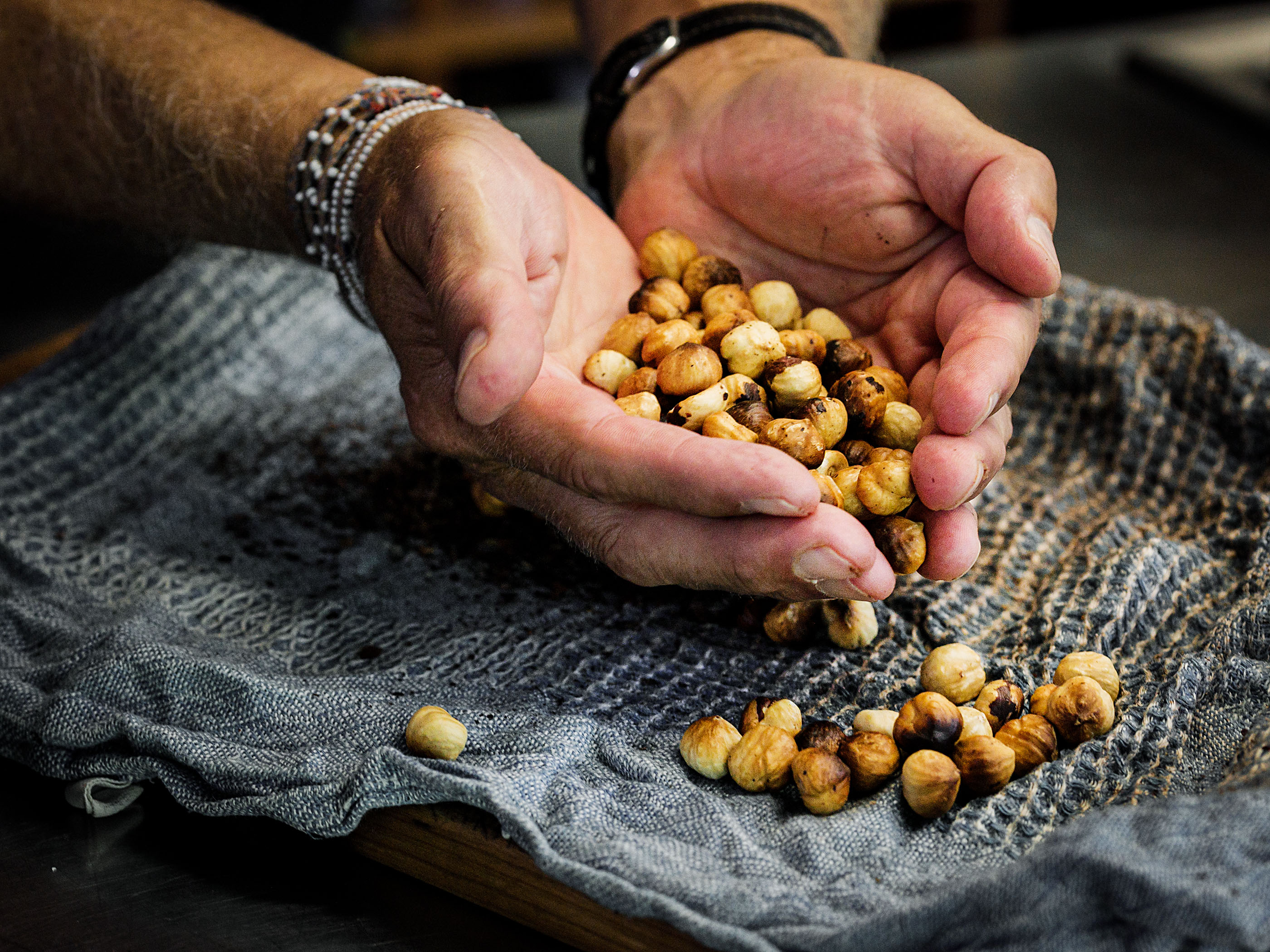 Schritt 2:  Haselnüsse in ein Tuch wickeln und mit dem Wallholz 2 bis 3 Mal darauf schlagen