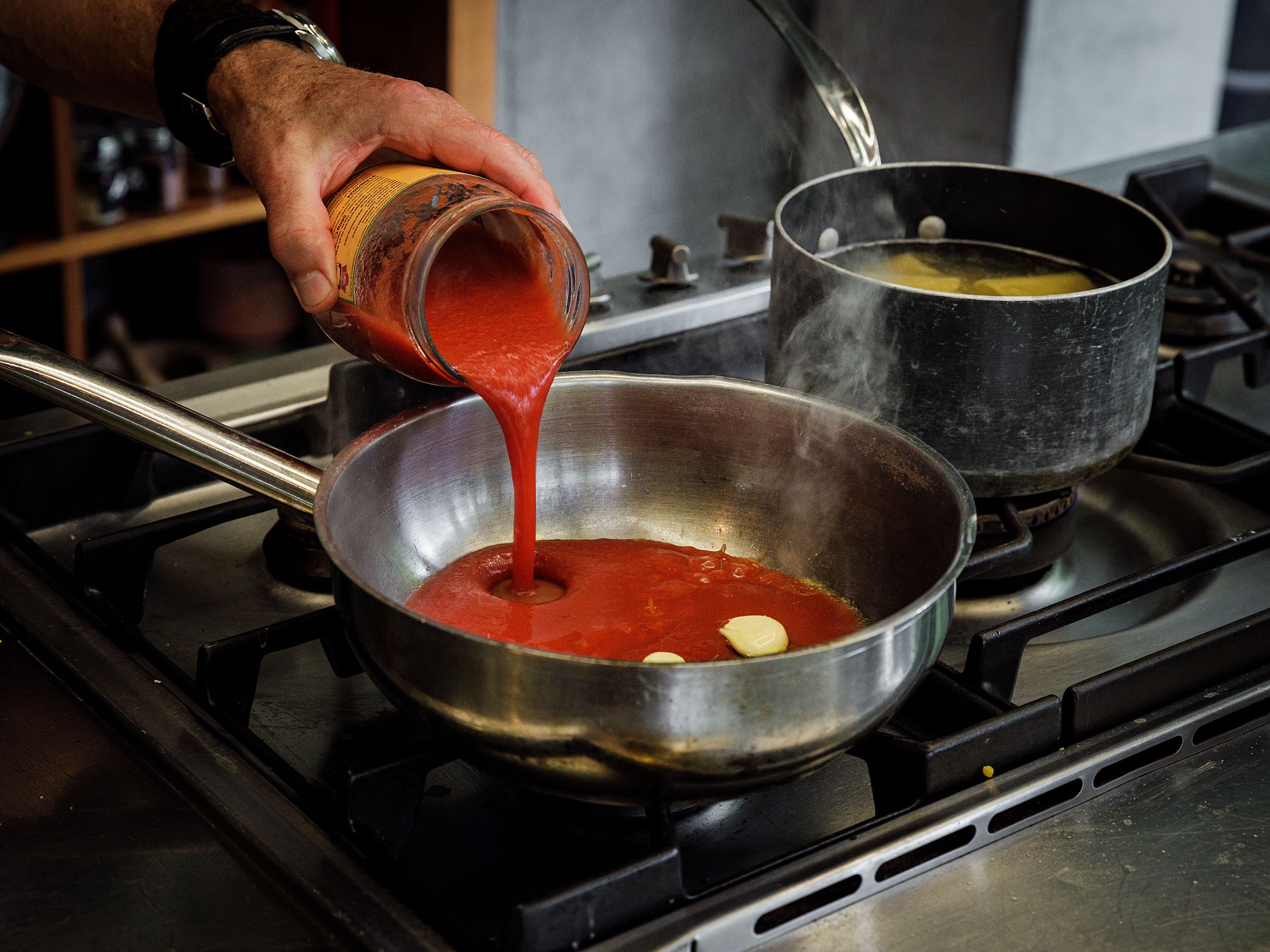 Schritt 2: Knoblauch im Olivenöl andünsten, Chili und Tomaten-Passata dazugeben und köcheln lassen