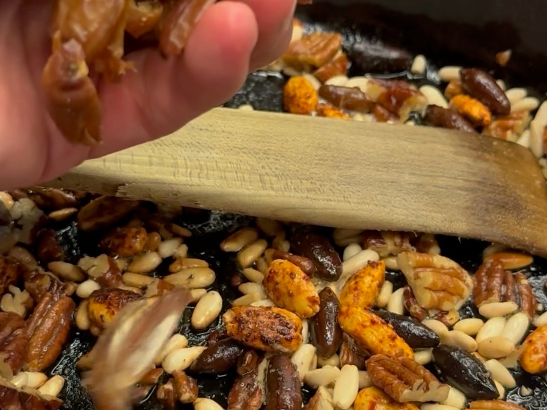 Schritt 2: Die Nüsse in einer heissen Pfanne zusammen mit Olivenöl rösten. Zum Schluss die Datteln mitrösten.