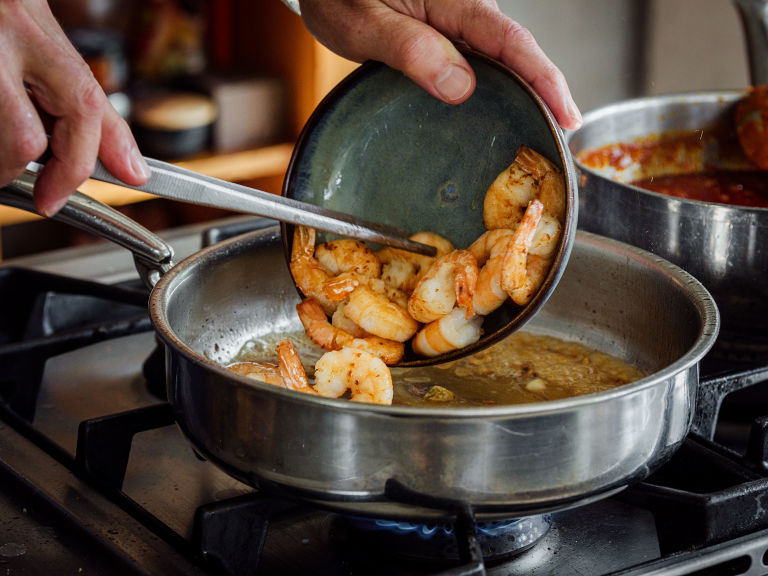 Schritt 2: Butter und Pimentón zugeben und unter vorsichtigem Wenden der Shrimps kochen, bis die Sauce aufschäumt