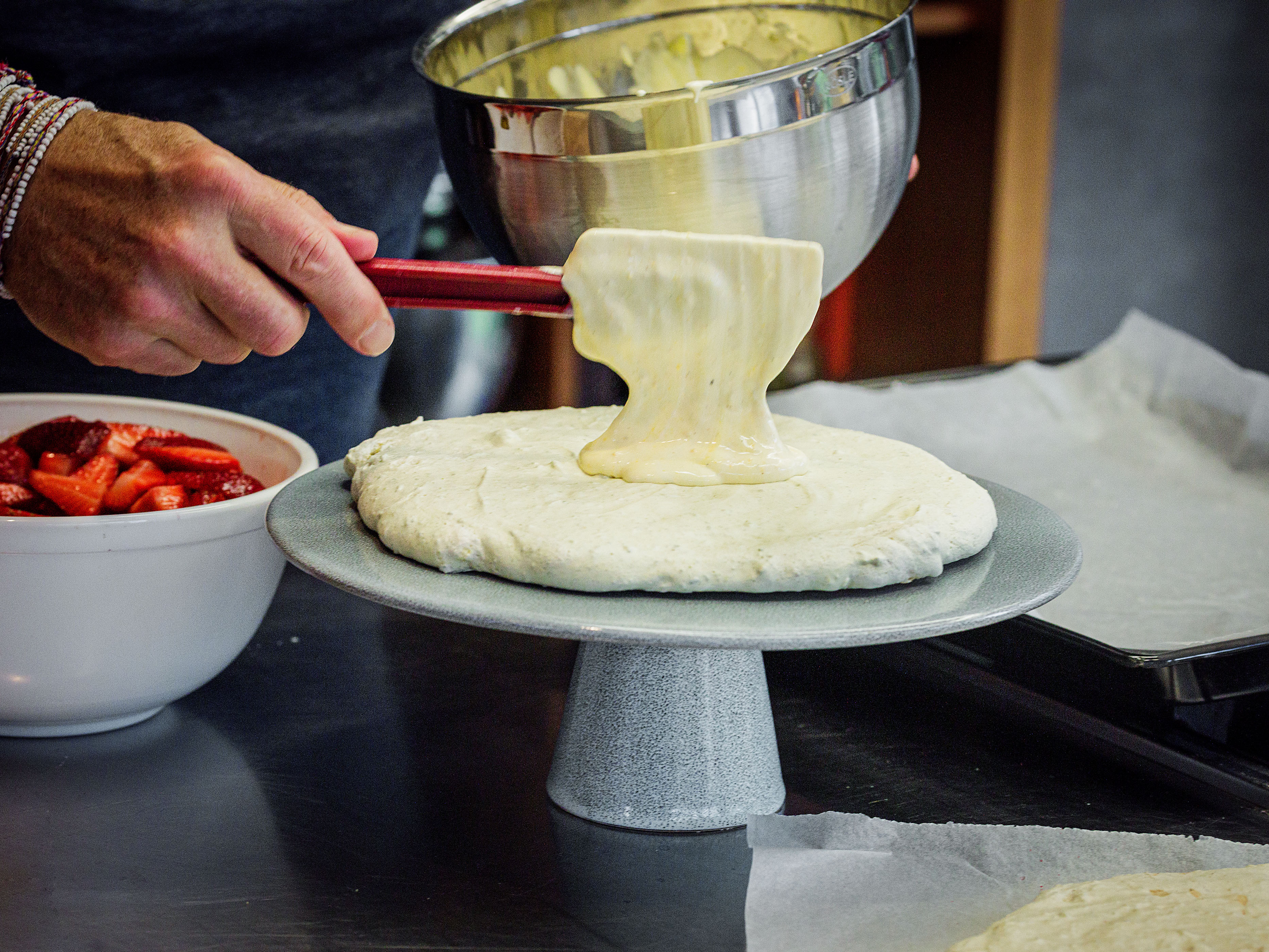 Schritt 4:  Eine Meringue-Scheibe auf eine Platte legen und ein Drittel der Creme gleichmässig darauf verteilen