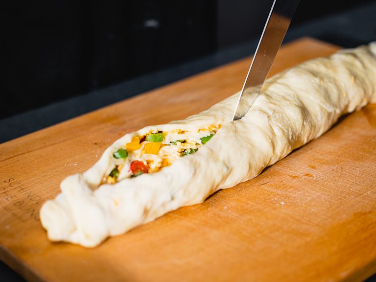 Schritt 2: Den Teig für den Chili-Käse-Zopf von der langen Seite her aufrollen und in der Mitte längs durchschneiden. Schritt 2: Den Teig für den Chili-Käse-Zopf von der langen Seite her aufrollen und in der Mitte längs durchschneiden.