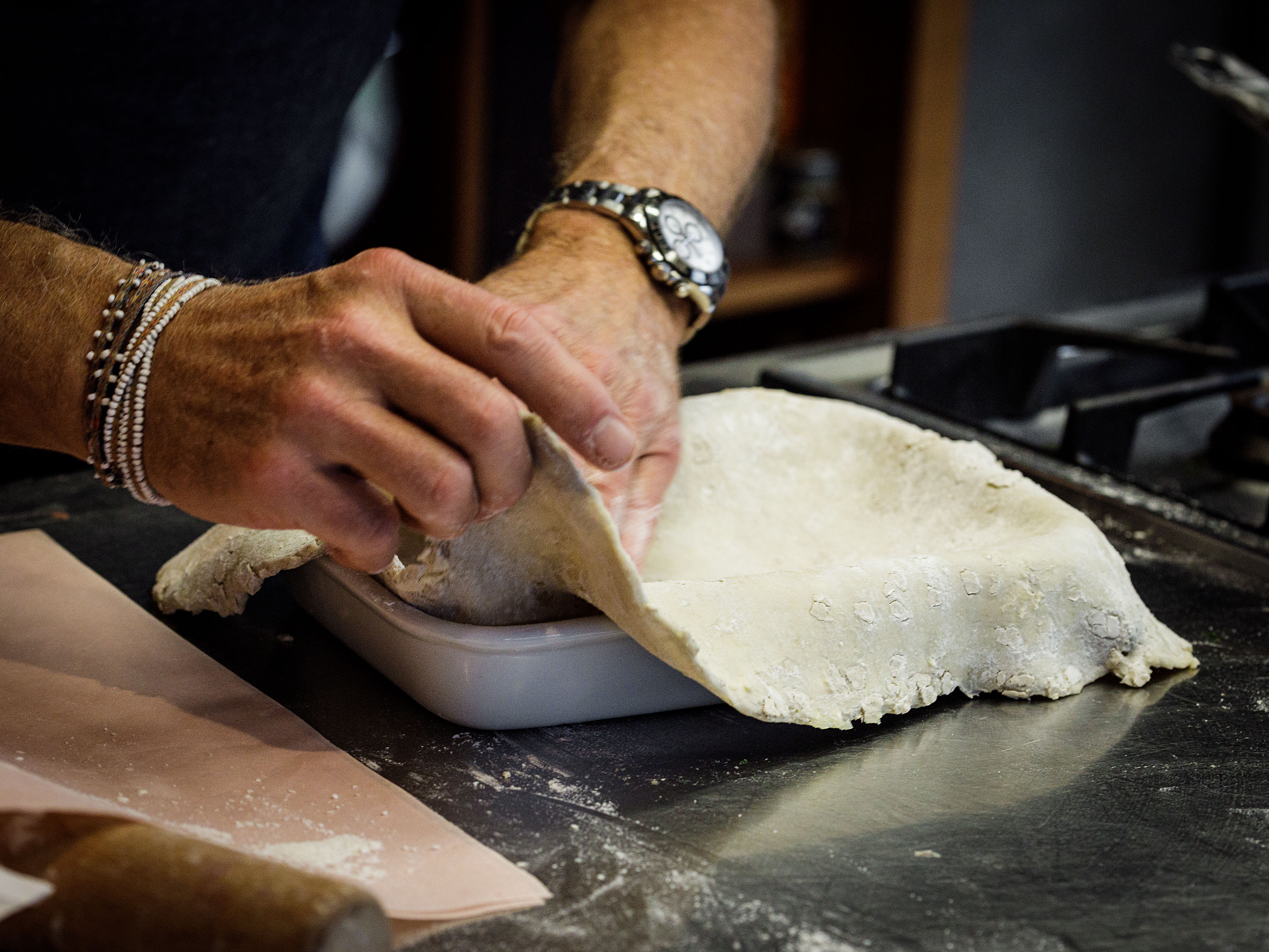 Schritt 2: Eine tiefe Form mit den Teig auskleiden, sodass er an den Seiten übersteht. 