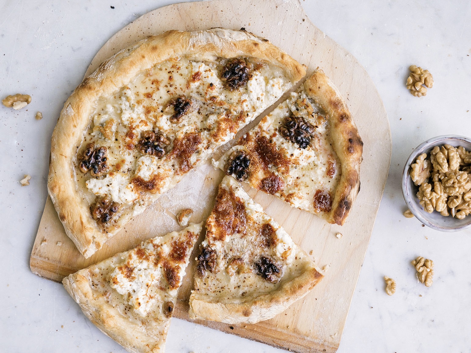 Schritt 2: Pizza quattro formaggi mit Baumnüssen belegen und backen