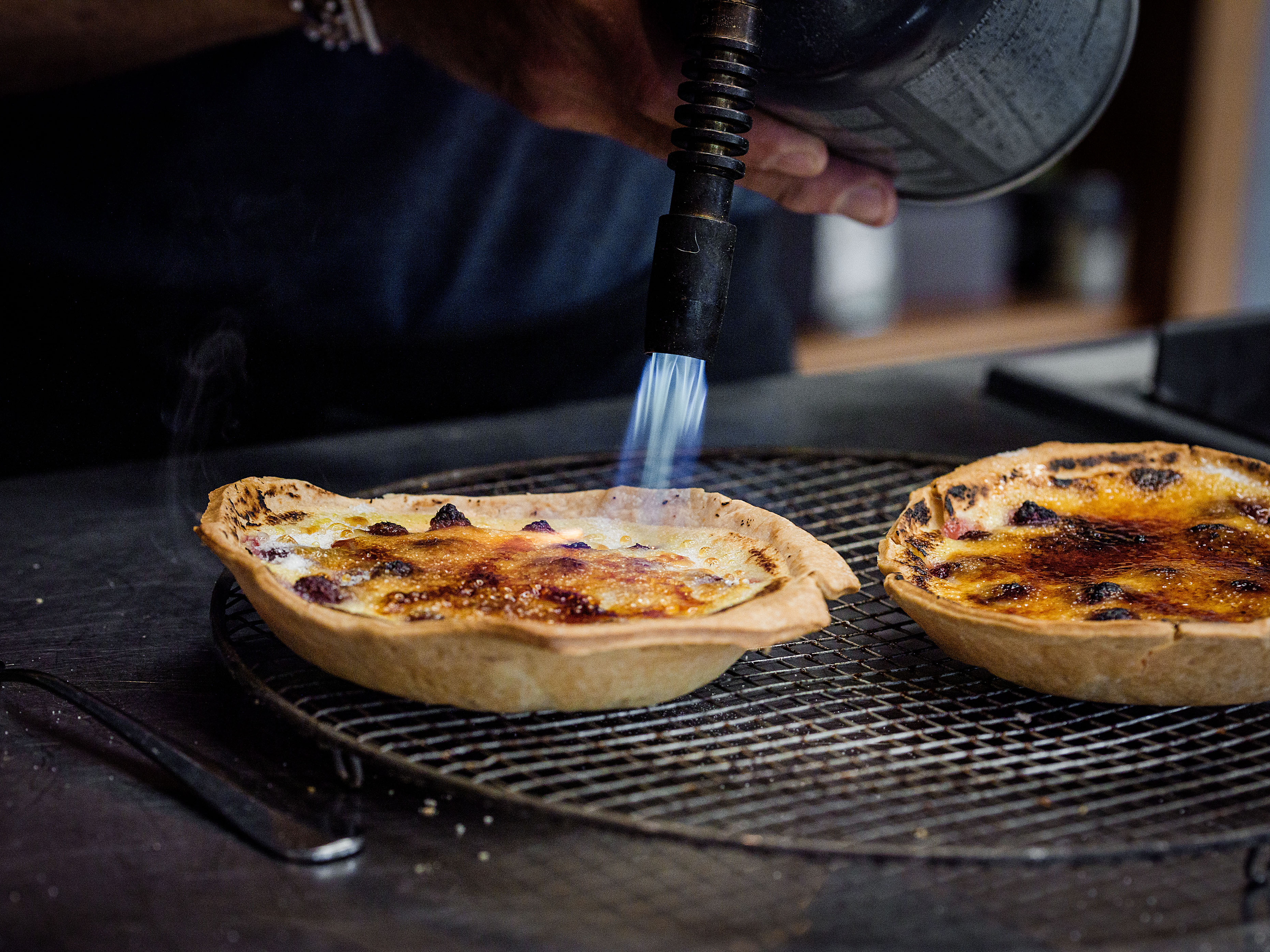Schritt 5: Zuckerkruste für Vanille-Himbeer Crème brûlée Tartelettes flämmen.
