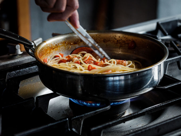 Schritt 3: Hummer zusammen mit den Estragonblättchen und dem zurückbehaltenen Pastawasser zu den Spaghetti geben.