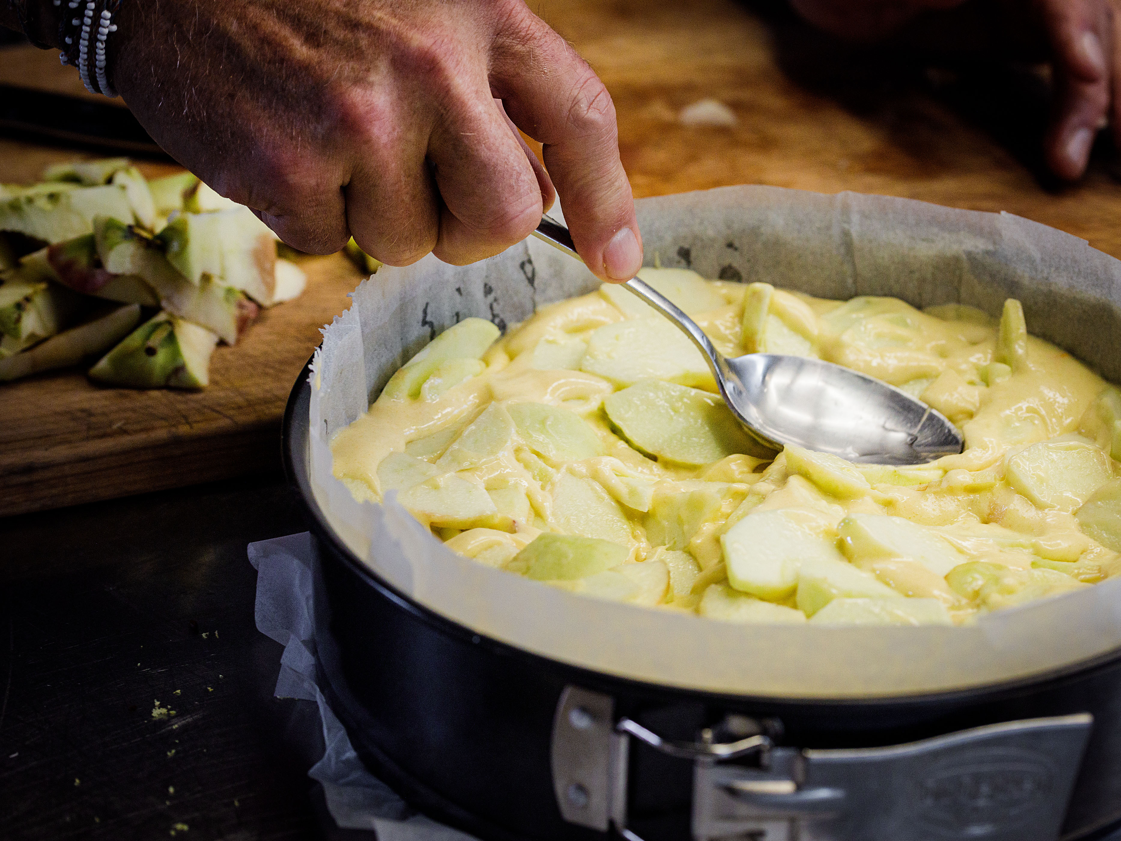 Schritt 2: Den Teig in die gebutterte Springform füllen, die Apfelscheiben leicht eindrücken und mit den Mandelsplittern bestreuen