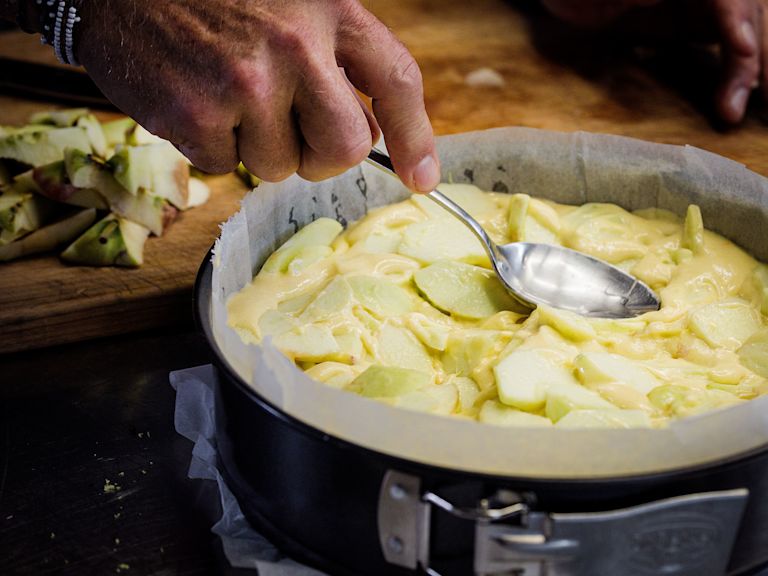 Schritt 2: Den Teig in die gebutterte Springform füllen, die Apfelscheiben leicht eindrücken und mit den Mandelsplittern bestreuen Schritt 2: Den Teig in die gebutterte Springform füllen, die Apfelscheiben leicht eindrücken und mit den Mandelsplittern bestreuen