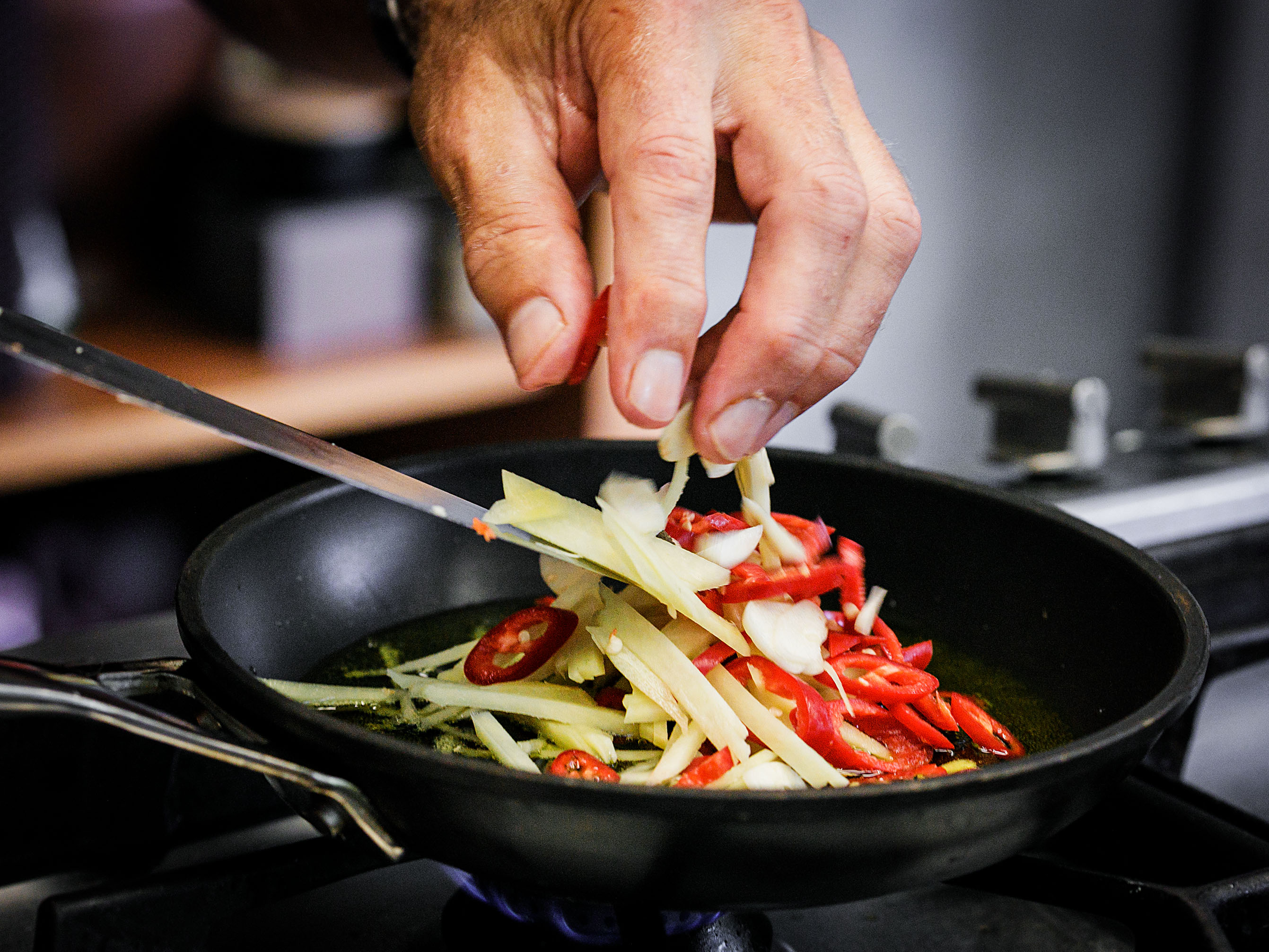 Schritt 1: Chili, Knoblauch sowie Ingwer fünf Minuten lang unter gelegentlichem Rühren in die Pfanne anbraten