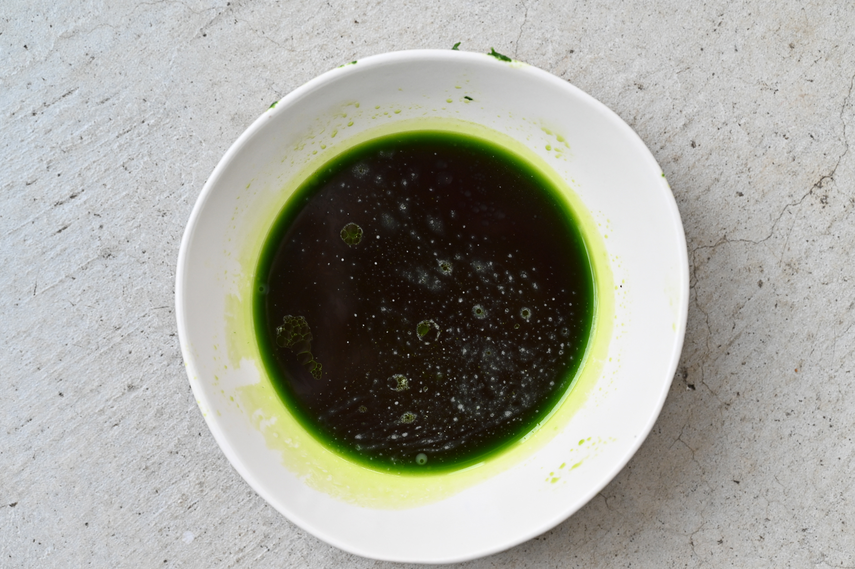 Schritt 2: Über einem Sieb aufhängen und das Öl in eine Schüssel abtropfen lassen.