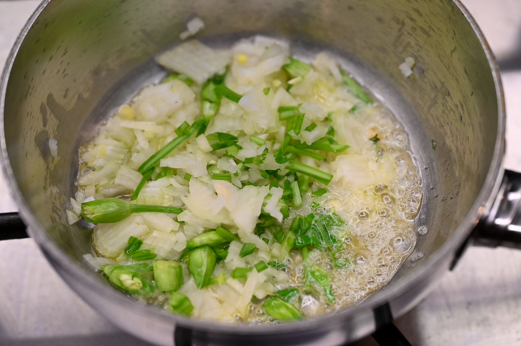 Schritt 1: Die Butter oder das Olivenöl erhitzen und die Zwiebeln, die gehackten Bärlauchstängel und die Bärlauchknospen darin einige Minuten langsam weich dünsten