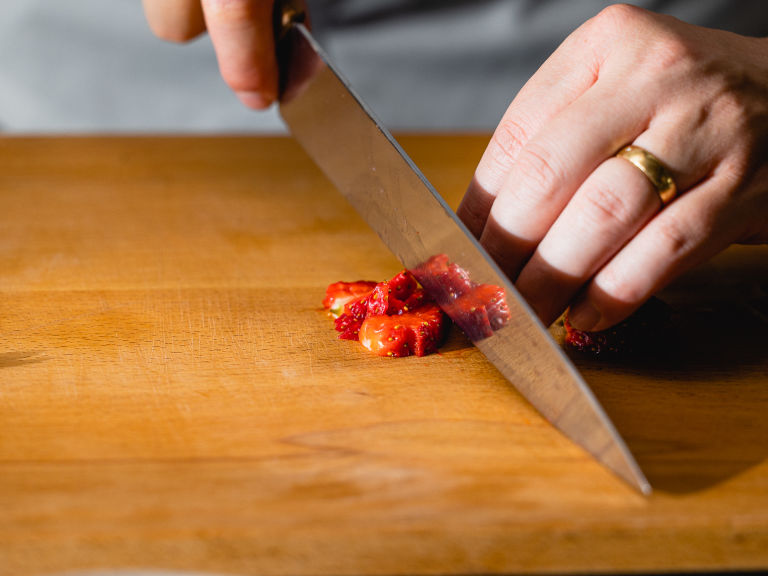 Schritt 1: Die Erdbeeren für Erdbeer-Tiramisu waschen, vom Strunk entfernen und in kleine Stücke schneiden.  