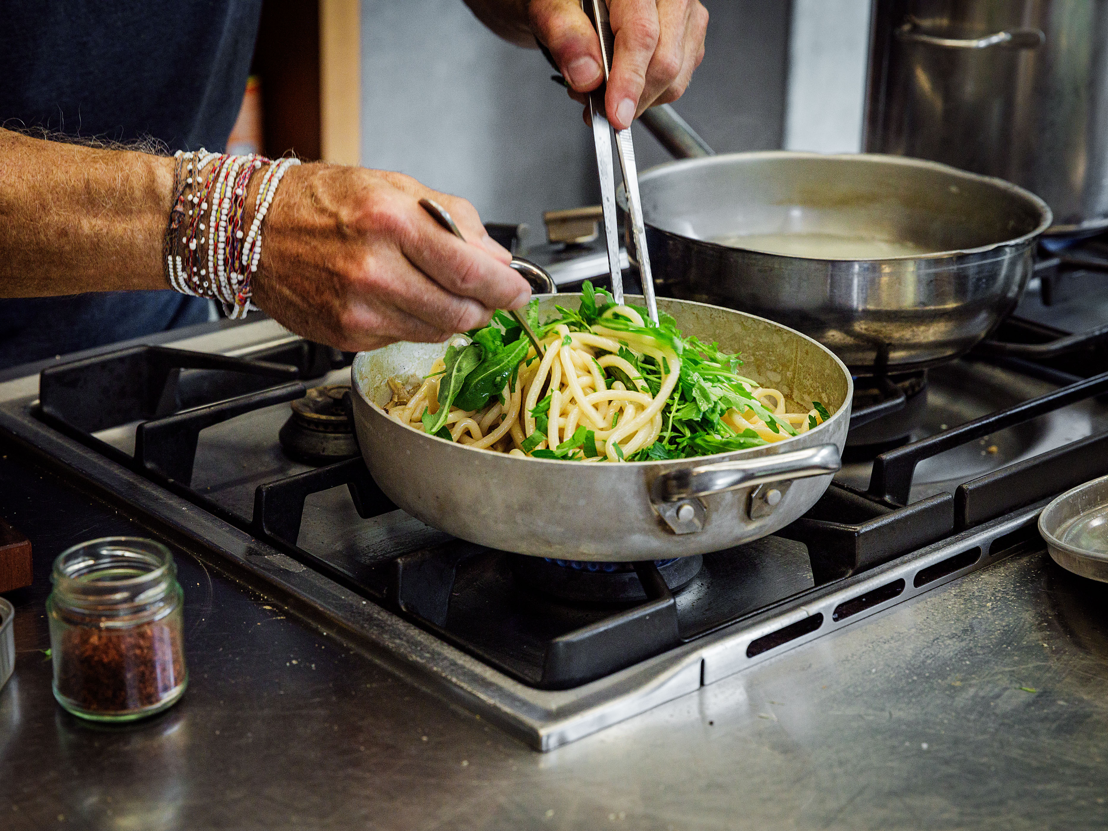Schritt 2: Pasta zugeben und mit Zwiebelgrün (falls vorhanden) und Rucola untermischen