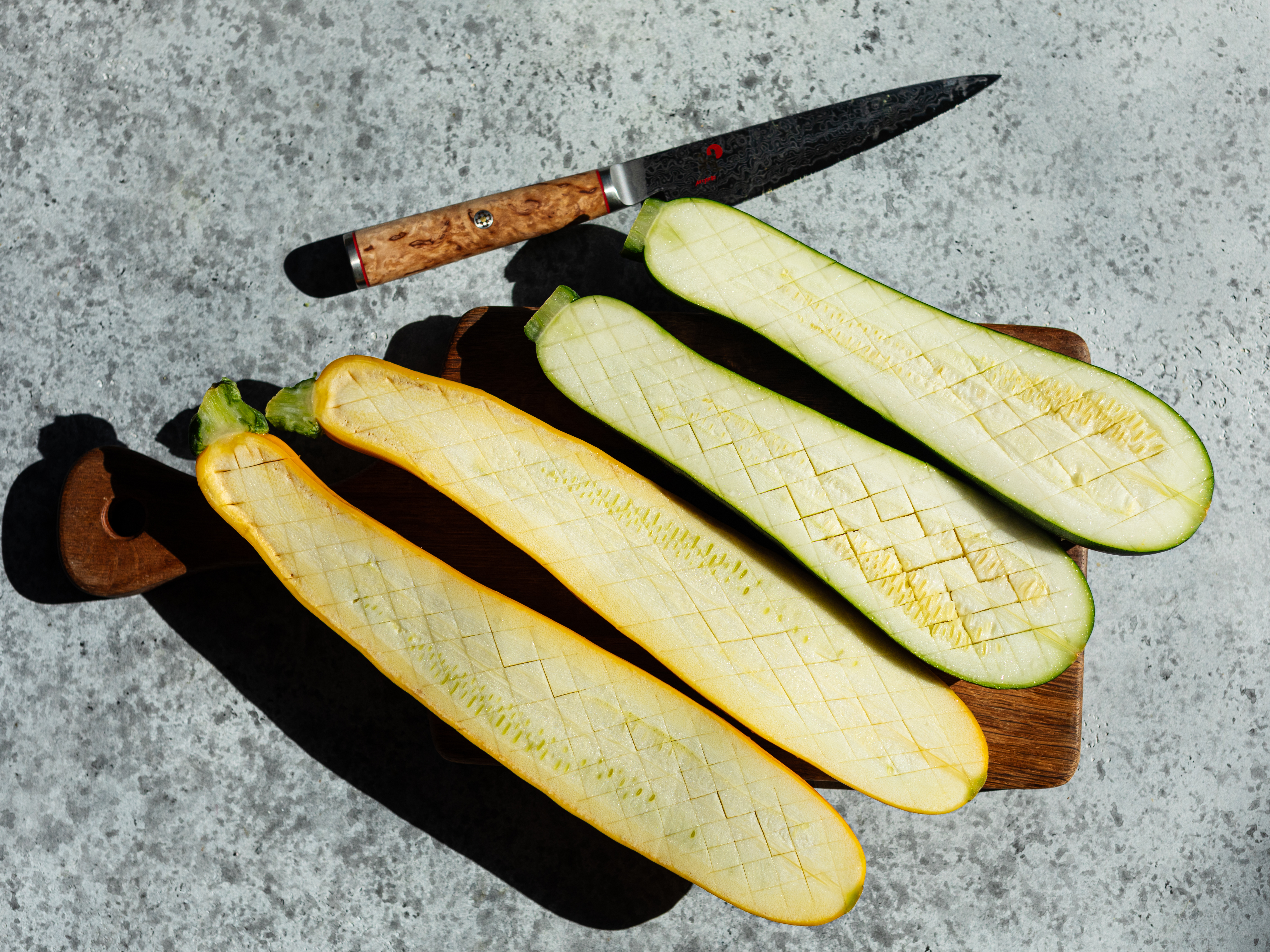 Schritt 1: Die Zucchetti gründlich waschen, der Länge nach halbieren und das Fleisch in einem Schachbrettmuster einschneiden, damit das Salz eindringen kann