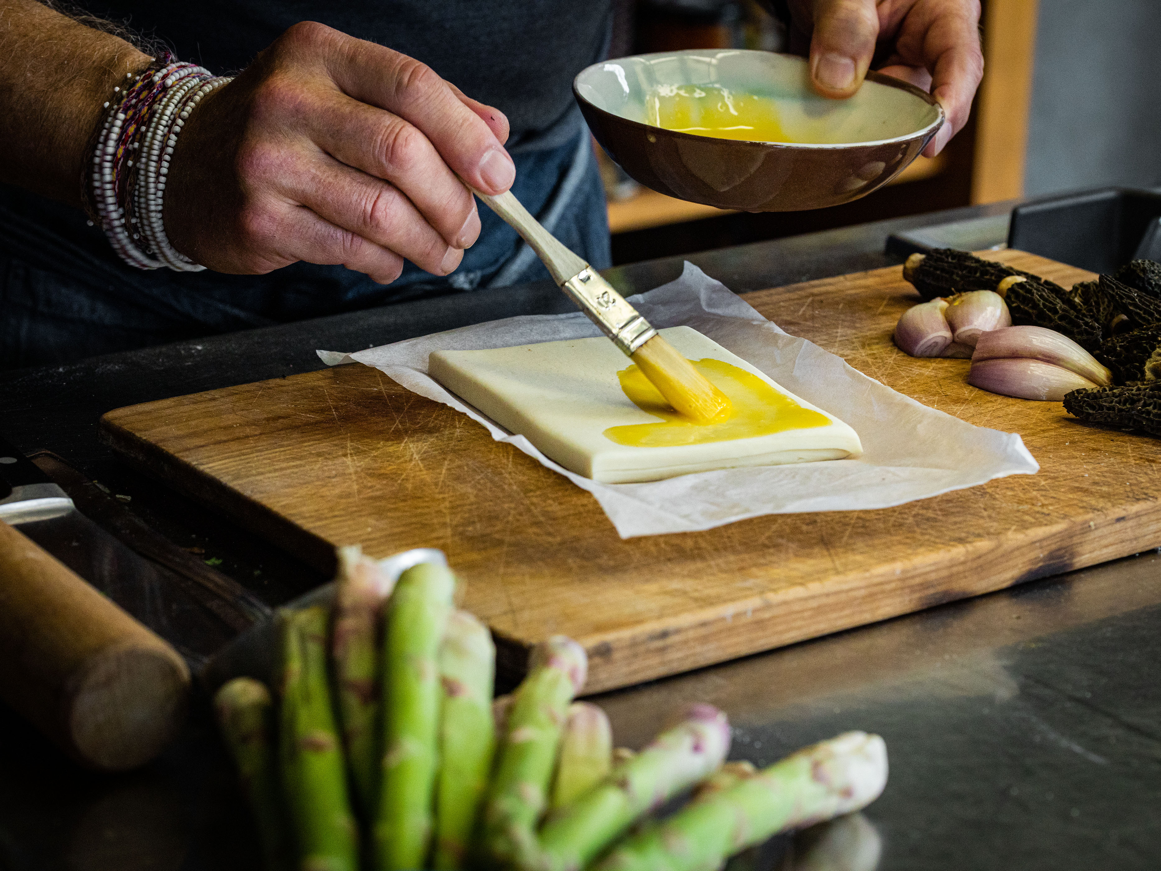 Schritt 1: In einer kleinen Schüssel das Eigelb mit einigen Tropfen kaltem Wasser verrühren und die Blätterteig-Rechtecke damit bestreichen