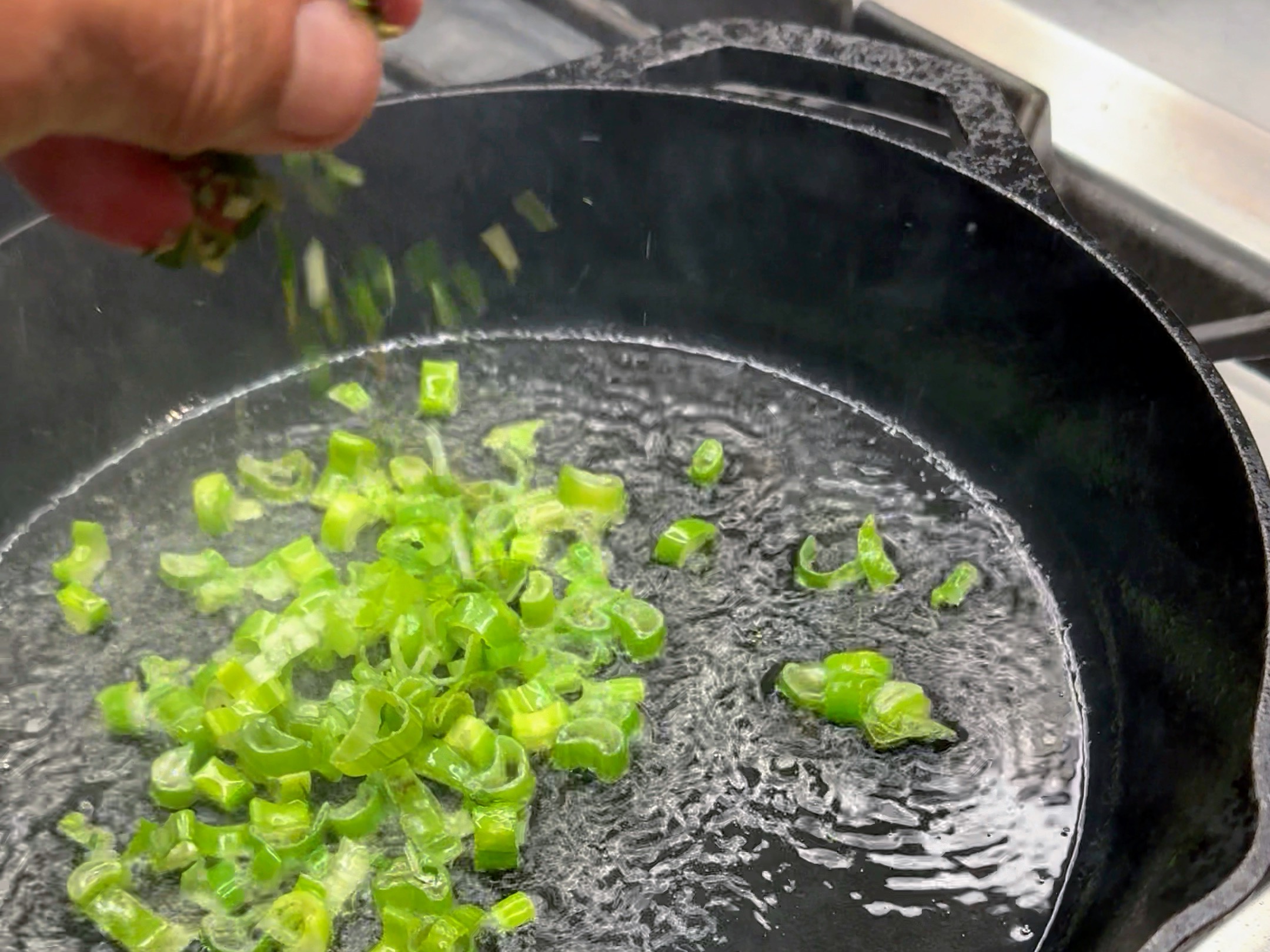 Schritt 3: Das Öl in die Pfanne geben, etwas Frühlingszwiebeln und Rosmarin dazugeben