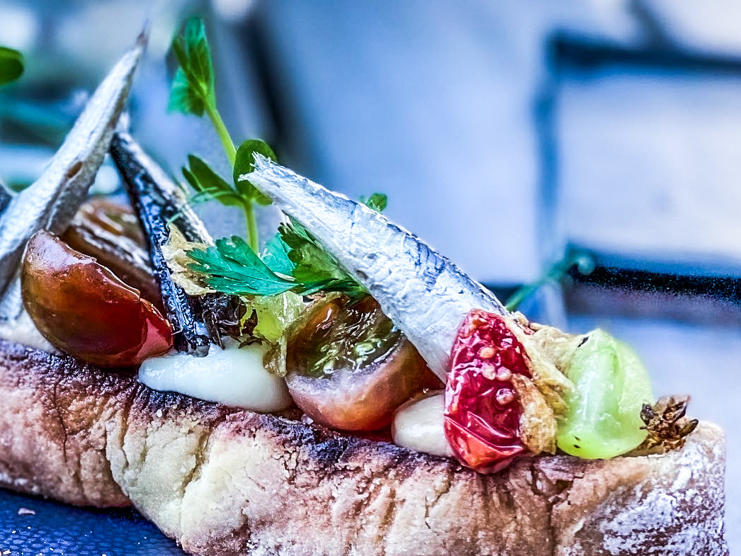 Schritt 2: Geröstete Brotscheiben mit allen gerösteten Zutaten und den Sardinen und Sardellen dekorativ belegen