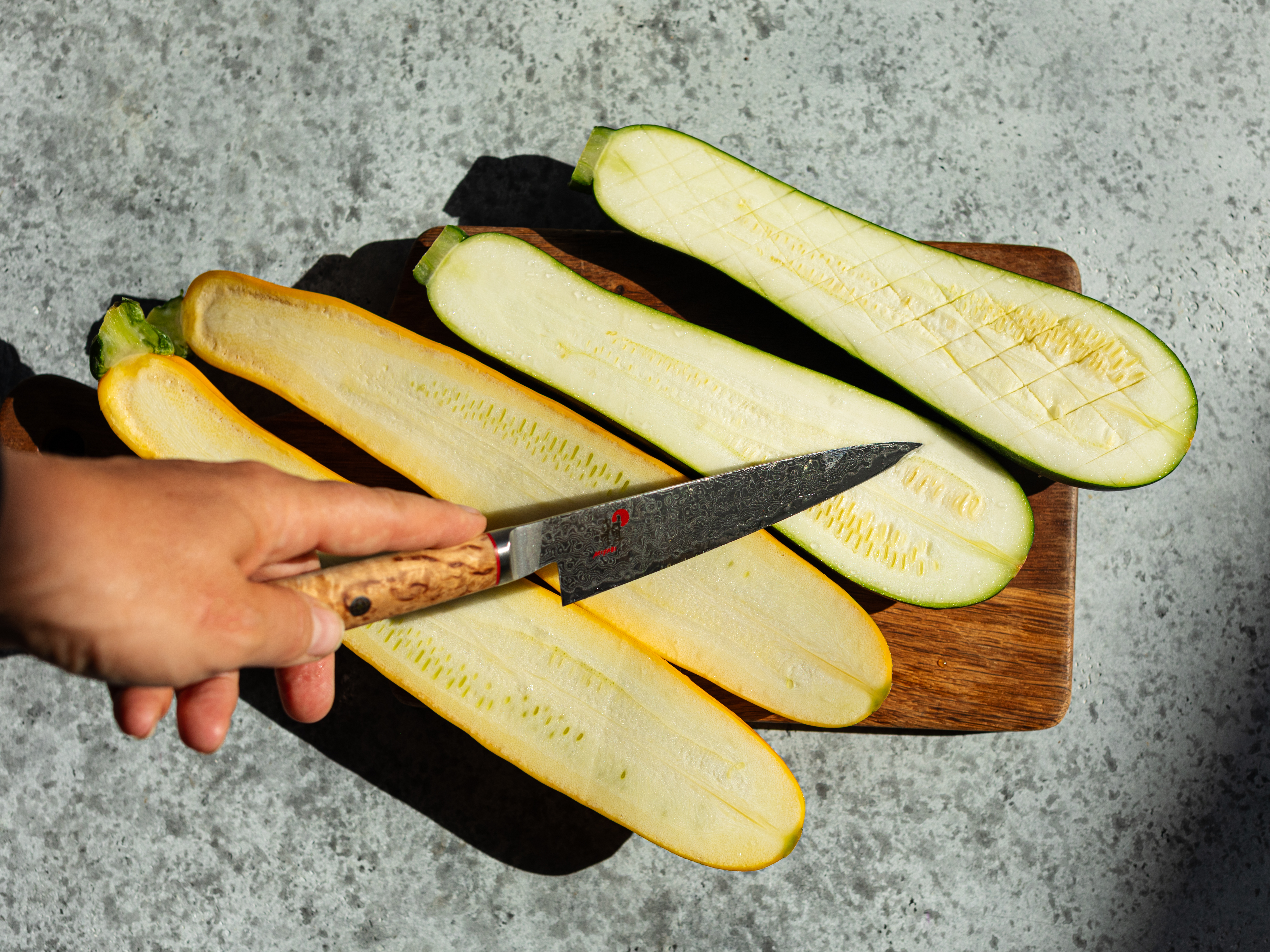 Schritt 1: Die Zucchetti gründlich waschen, der Länge nach halbieren und das Fleisch in einem Schachbrettmuster einschneiden, damit das Salz eindringen kann