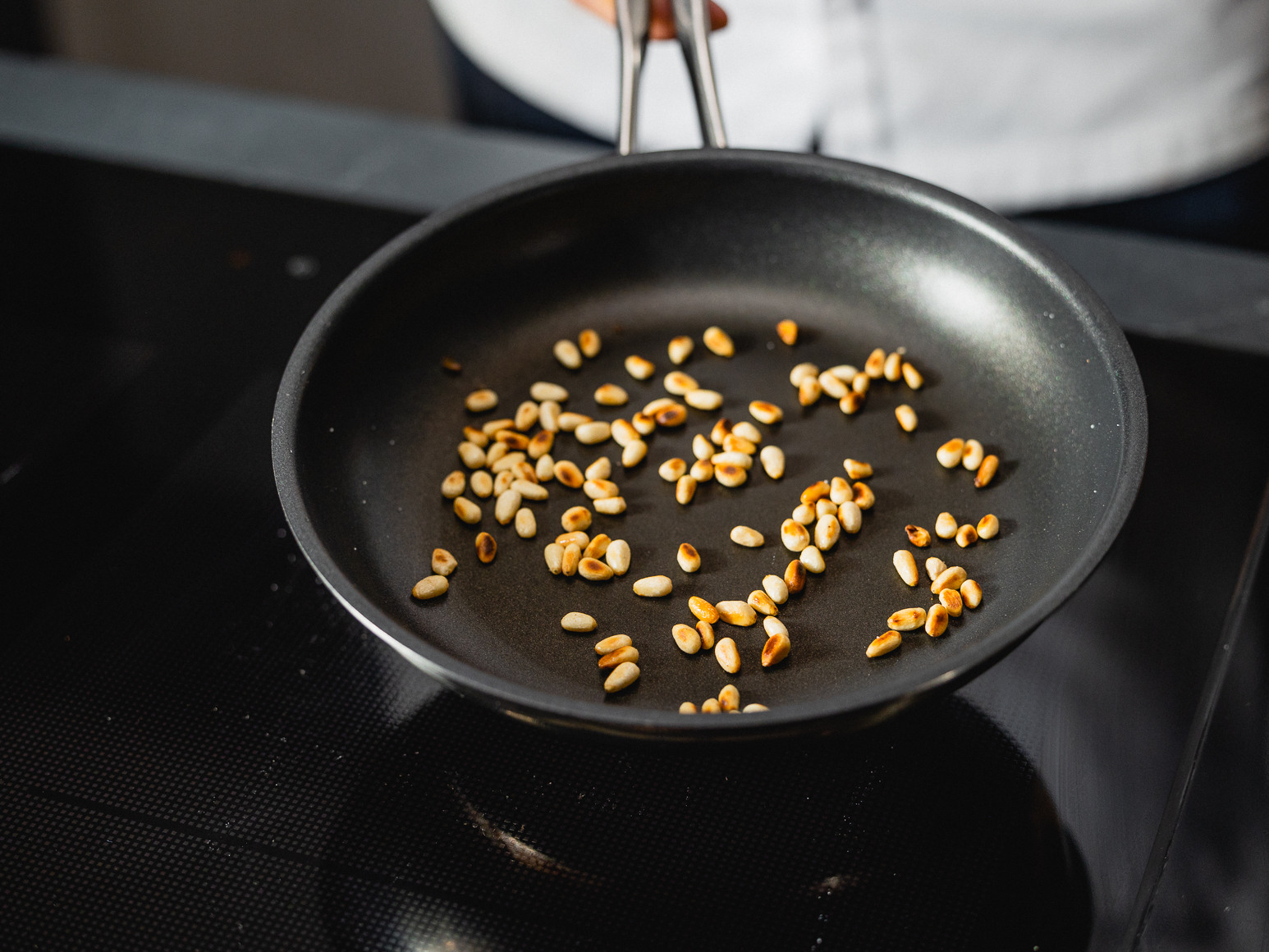Schritt 2: Pinienkerne für Spinat-Spätzli mit frittiertem Spinat, Pinienkernen und Parmesan  in einer Bratpfanne ohne Fettzugabe goldgelb rösten und beiseite legen. 