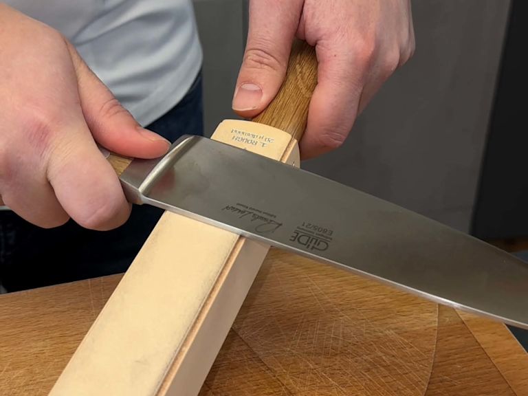 Step 1: Messer - von oben nach unten - über die erste Seite des Streichriemens ziehen Step 1: Messer - von oben nach unten - über die erste Seite des Streichriemens ziehen