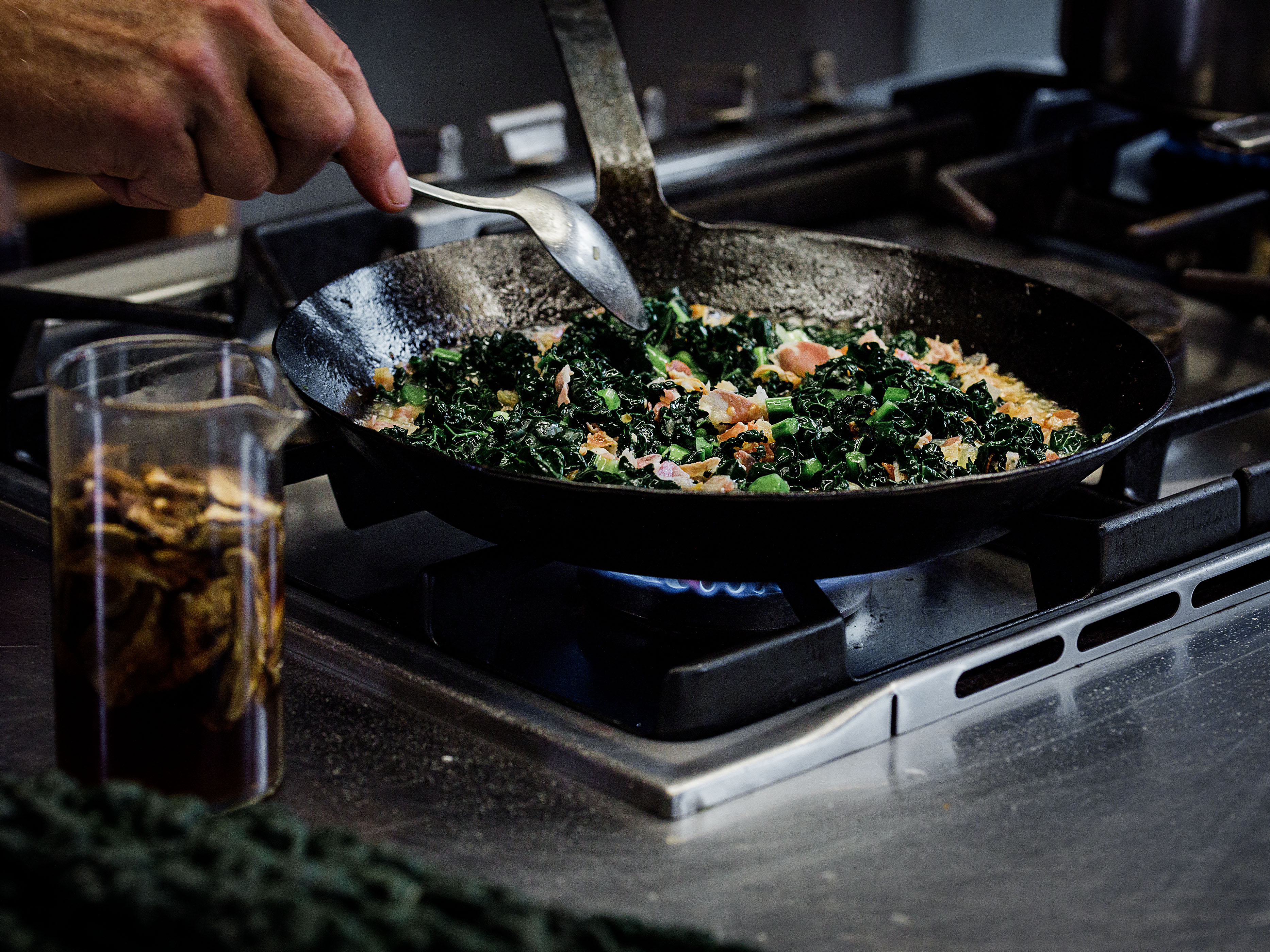 Schritt 1: Wein und Cavolo nero (Schwarzkohl) zugeben und kochen, bis der Wein reduziert ist und der Cavolo nero zusammengefallen ist