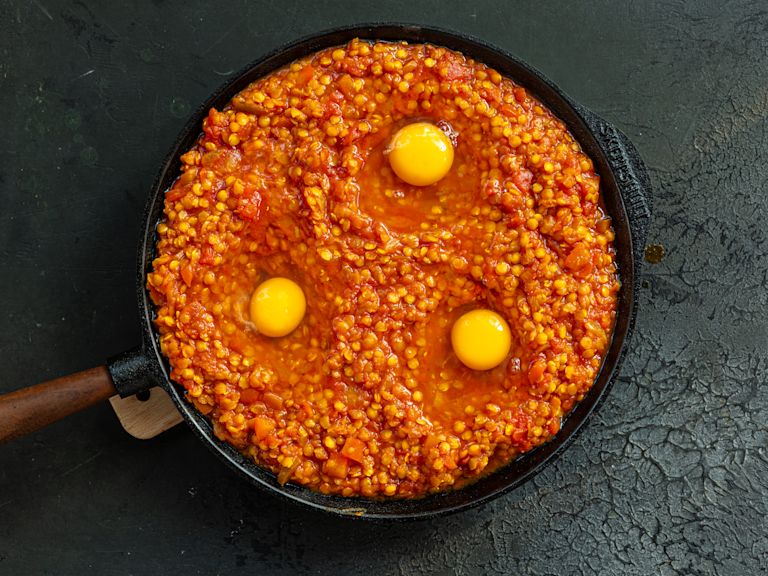 Schritt 3: Mit einem Löffel Vertiefungen in die Linsen machen und jeweils ein Ei in jede Vertiefung aufschlagen Schritt 3: Mit einem Löffel Vertiefungen in die Linsen machen und jeweils ein Ei in jede Vertiefung aufschlagen