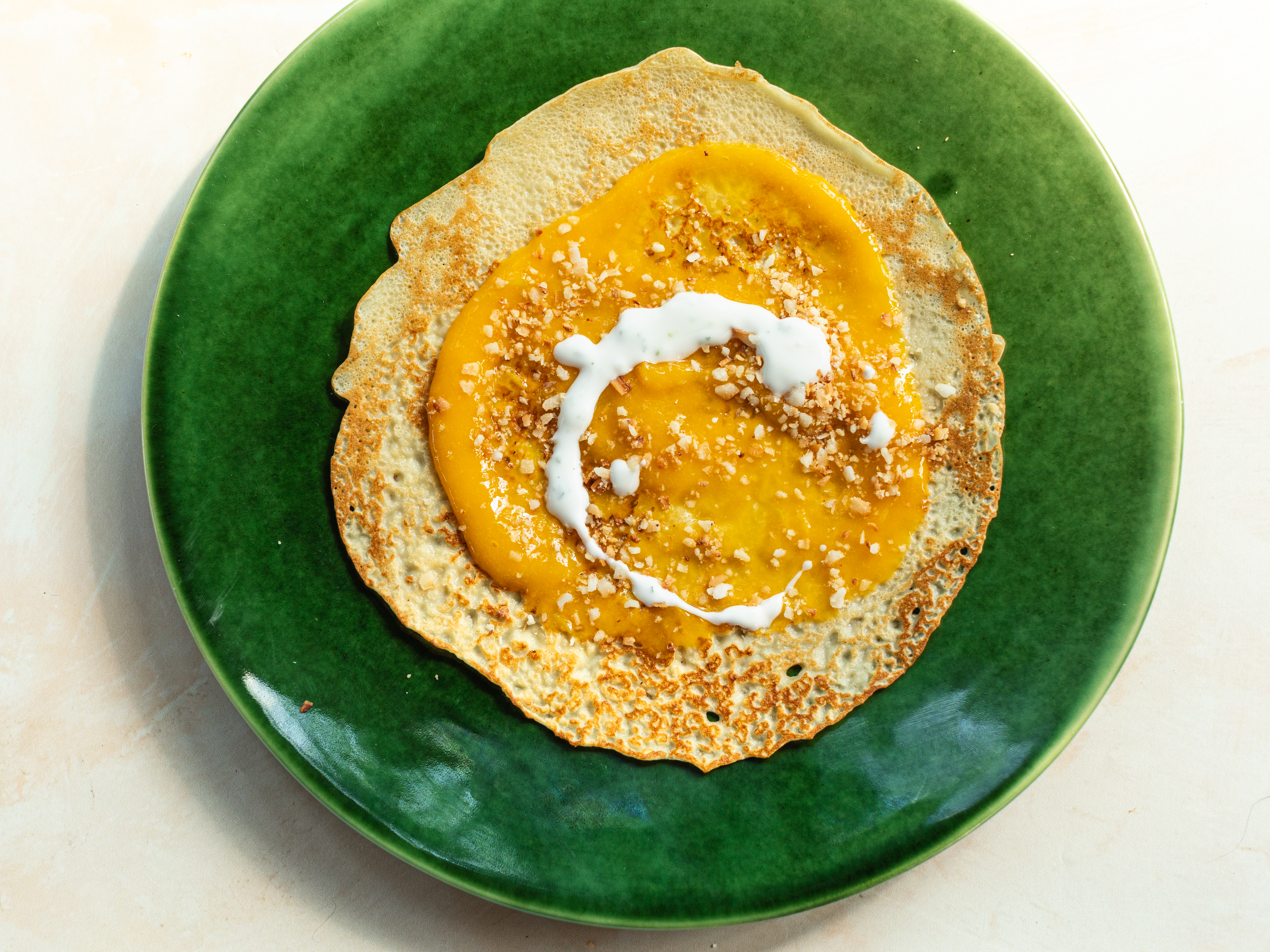 Schritt 6: Die fertigen Crêpes mit Mango Püree, Joghurt und Kokosraspeln füllen und zusammenklappen