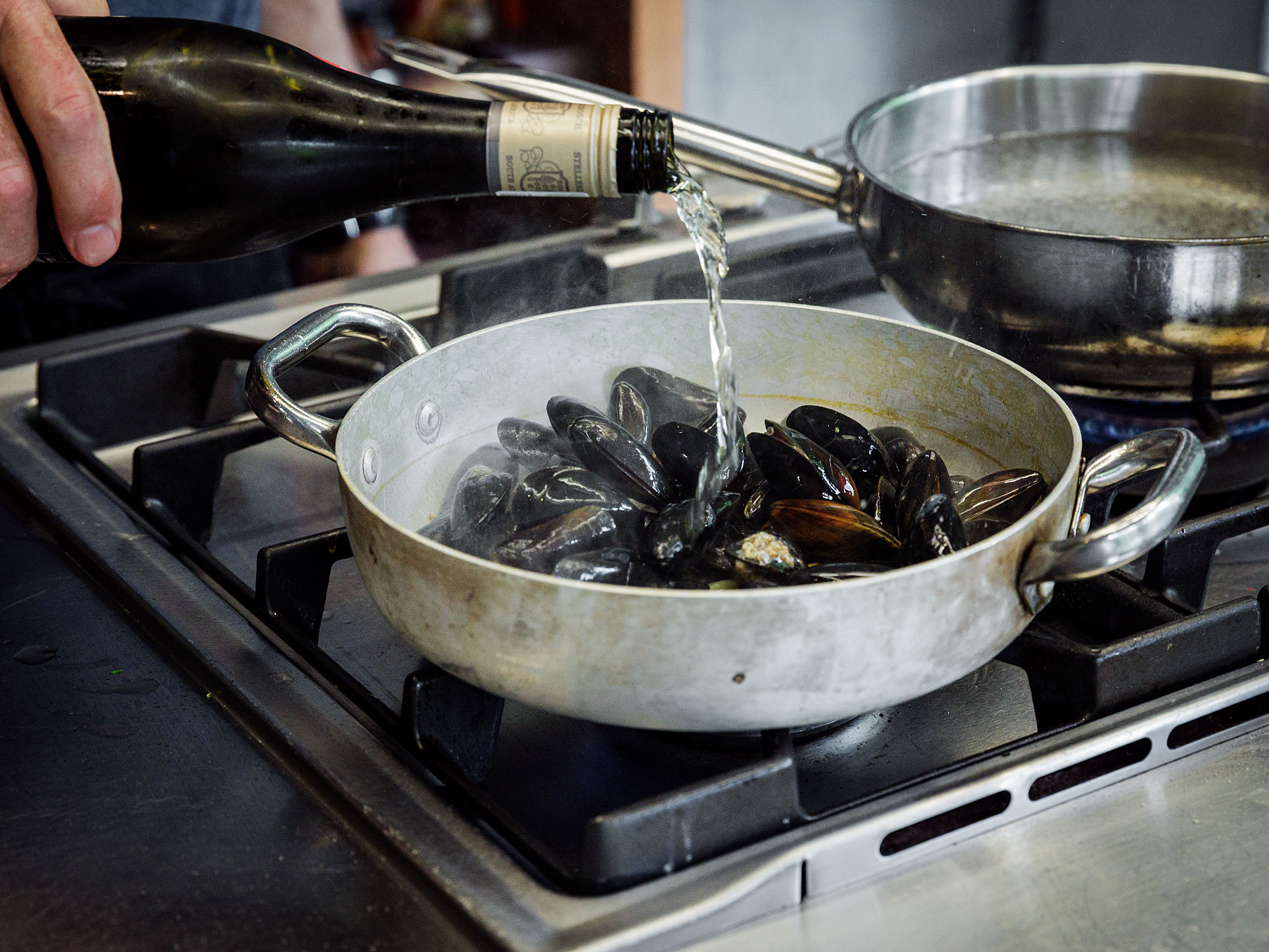 Schritt 3: Die Hitze in der Kasserole erhöhen, Muscheln und Wein zum Gemüse einrühren und garen