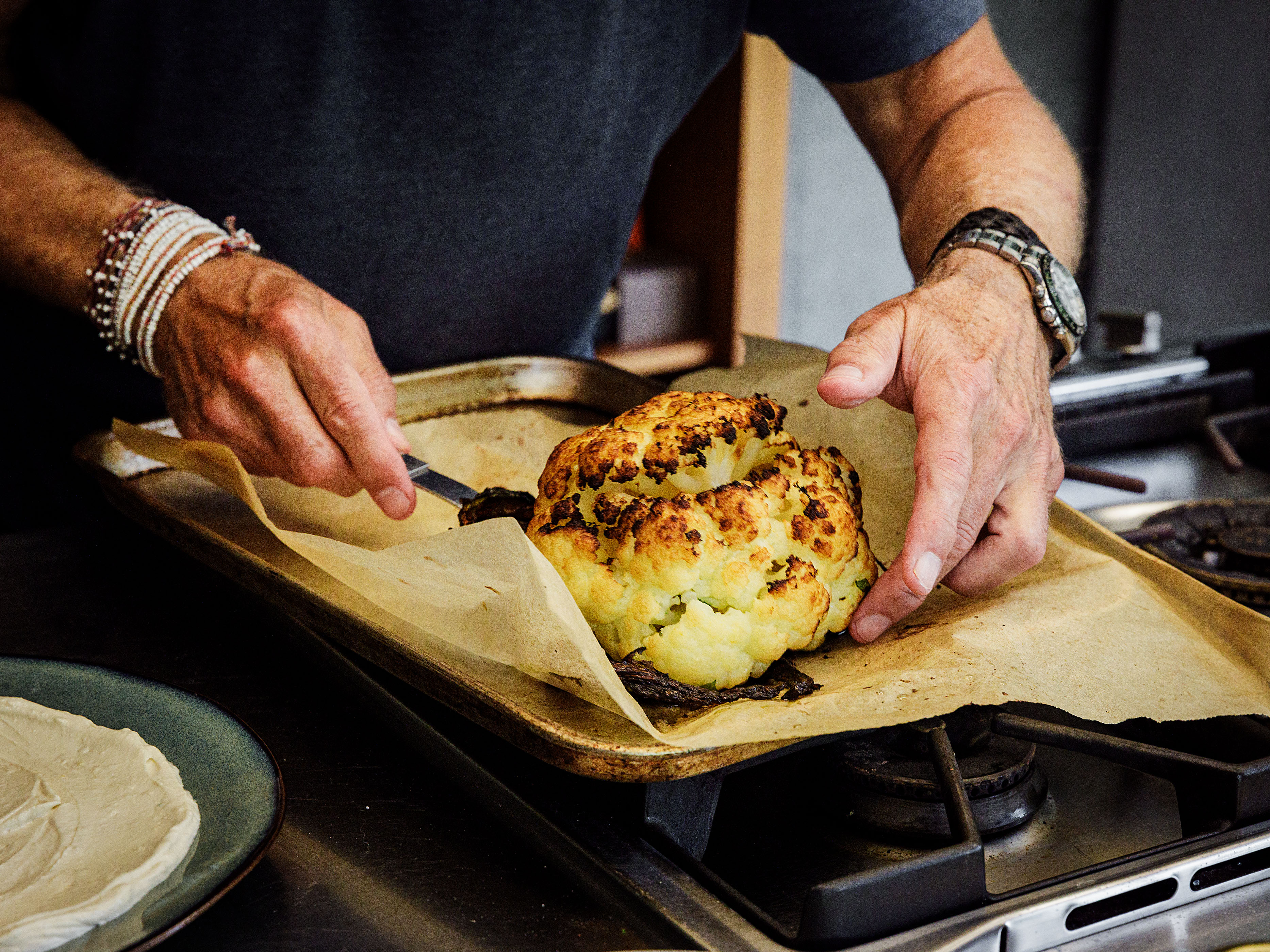 Schritt 3: Die Joghurt-Tahin-Sauce auf einem grossen Teller verteilen und den Blumenkohl darauf anrichten