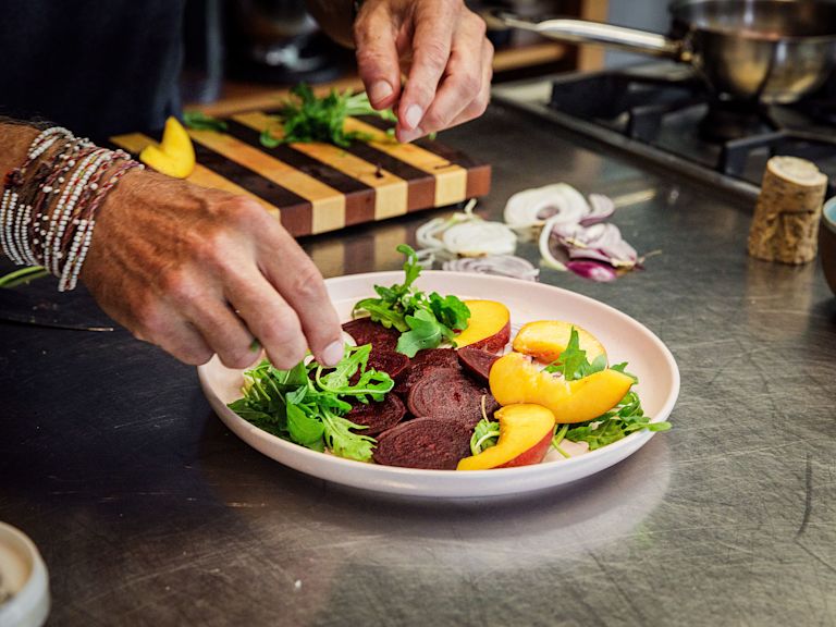 Schritt 4: Die Randen- und Zwiebelscheiben zusammen mit den Nektarinenspalten oder den Orangenscheiben und dem Rucola auf einer Servierplatte arrangieren Schritt 4: Die Randen- und Zwiebelscheiben zusammen mit den Nektarinenspalten oder den Orangenscheiben und dem Rucola auf einer Servierplatte arrangieren