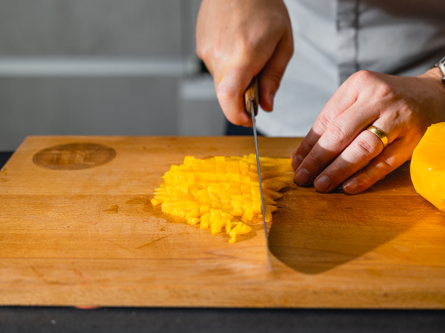 Schritt 1: Mangos für Mango-Kokos-Tiramisu mit Limetten-Creme schälen, das Fruchtfleisch in kleine Würfel schneiden und in eine Schüssel geben.  