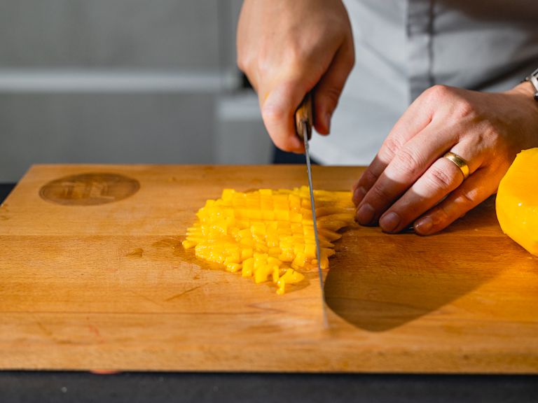 Schritt 1: Mangos für Mango-Kokos-Tiramisu mit Limetten-Creme schälen, das Fruchtfleisch in kleine Würfel schneiden und in eine Schüssel geben. Schritt 1: Mangos für Mango-Kokos-Tiramisu mit Limetten-Creme schälen, das Fruchtfleisch in kleine Würfel schneiden und in eine Schüssel geben.