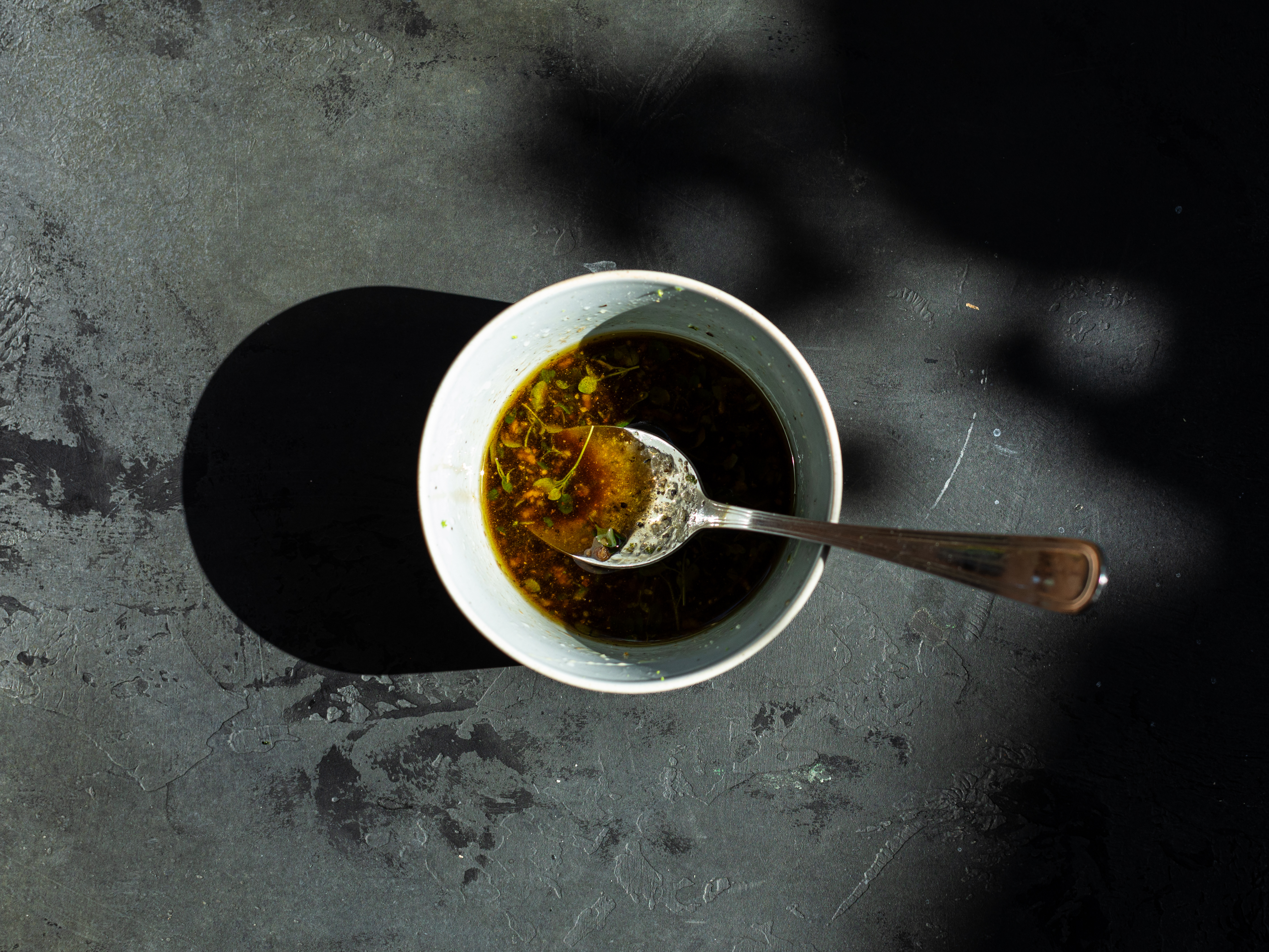 Schritt 2: Den Knoblauch fein hacken, Thymian waschen und abzupfen. In einer Schüssel Olivenöl, Balsamico-Essig, Limettensaft, Limettenabrieb, Honig, den Thymian, gehackten Knoblauch, Chiliflocken (falls verwendet), Salz und Pfeffer vermischen