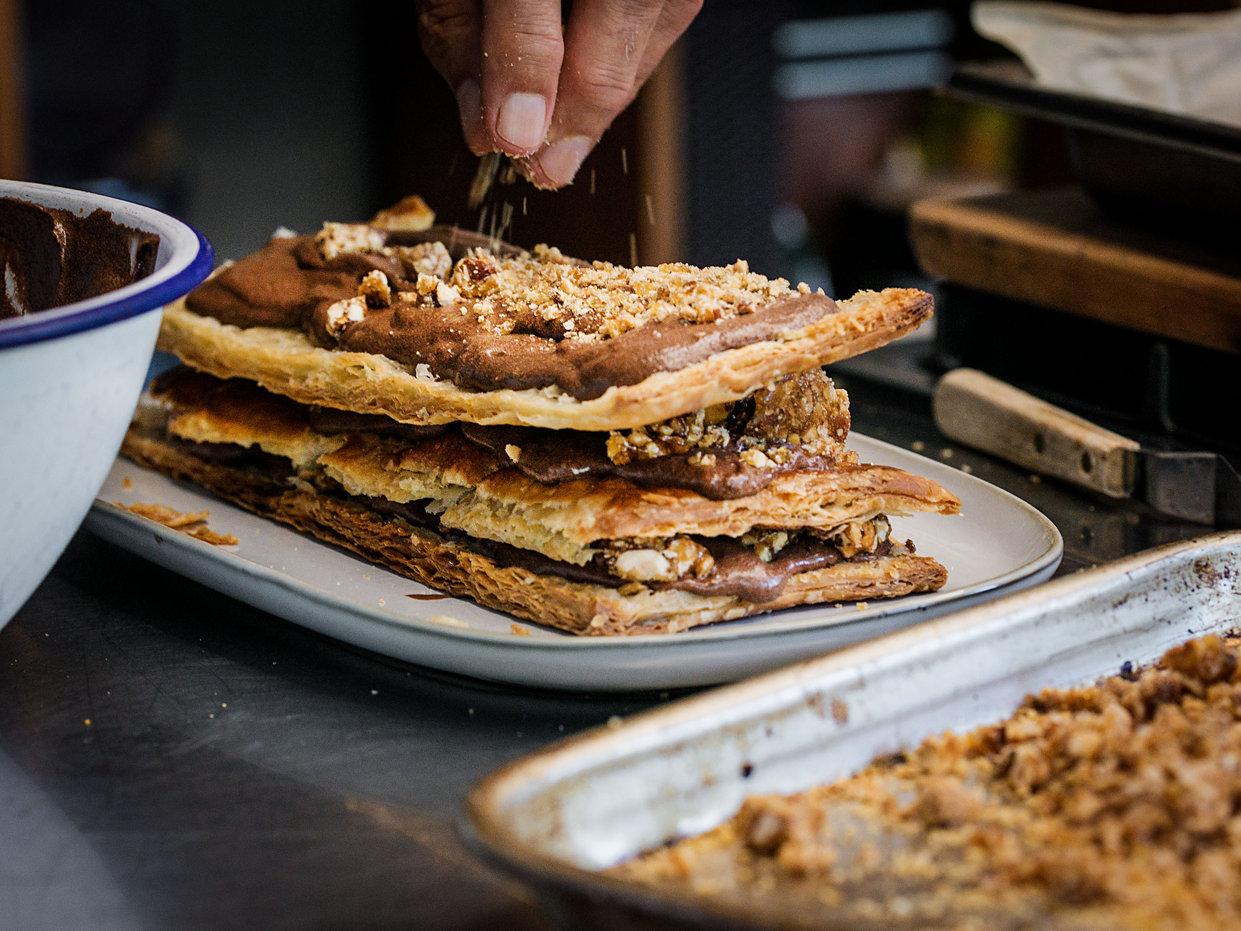 Schritt 5:  Etwas vom gehackten Praliné darüber streuen, dann mit einem weiteren Blätterteig-Rechteck belegen. 