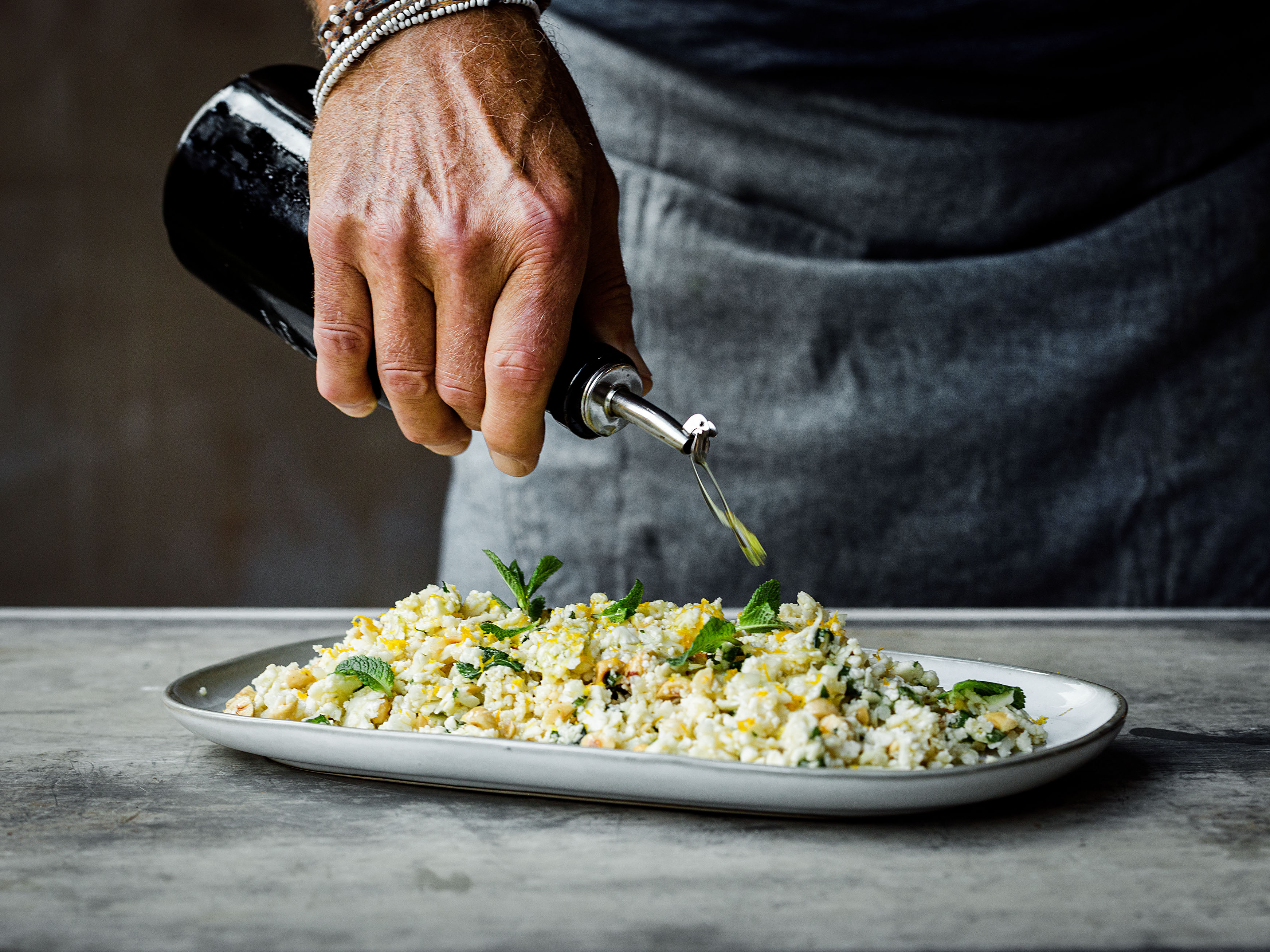 Schritt 2: Blumenkohl-Couscous mit Olivenöl anrichten.