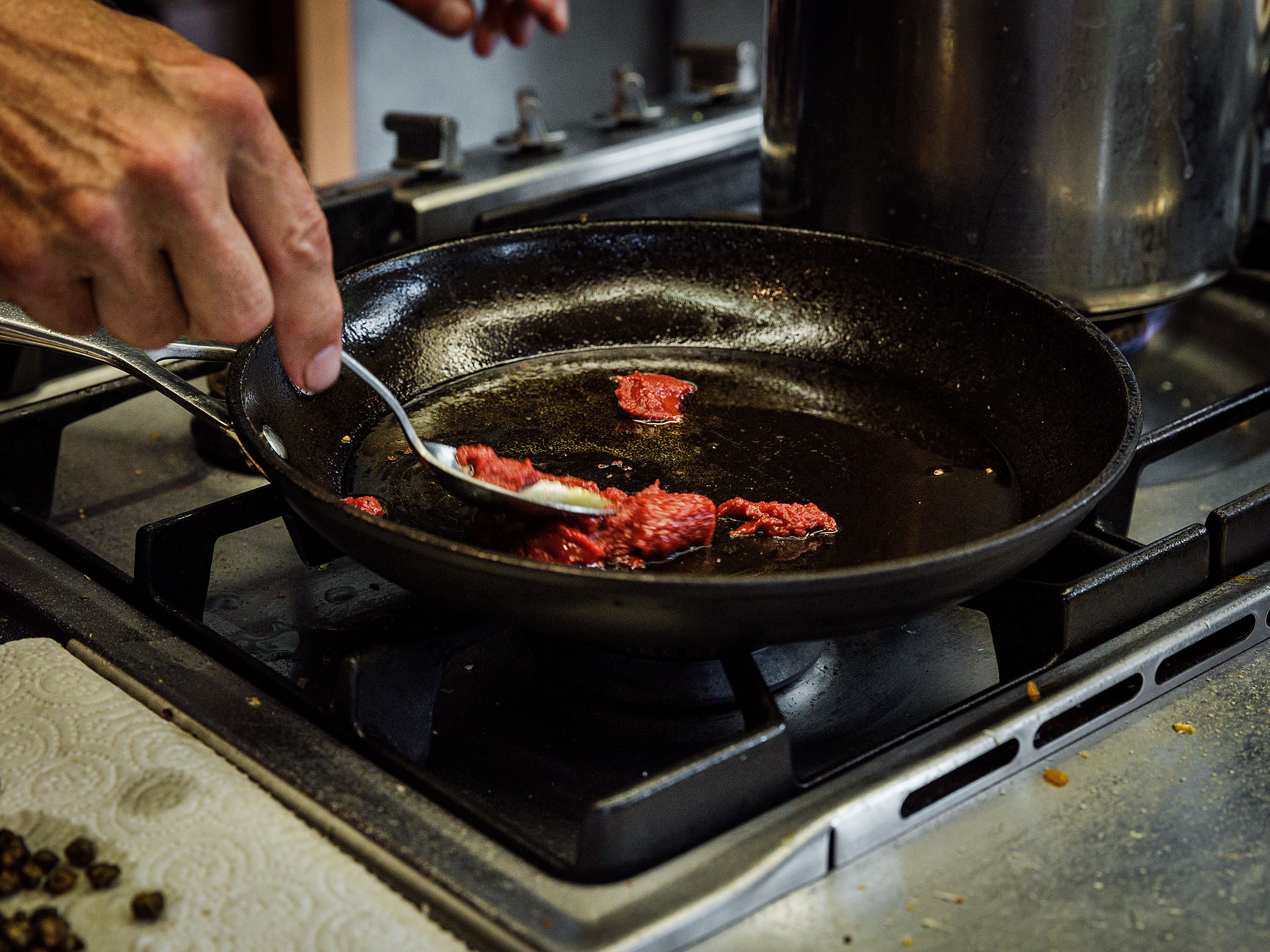 Schritt 2: Das Tomatenmark in die Pfanne geben und bei mittlerer Hitze unter häufigem Rühren braten