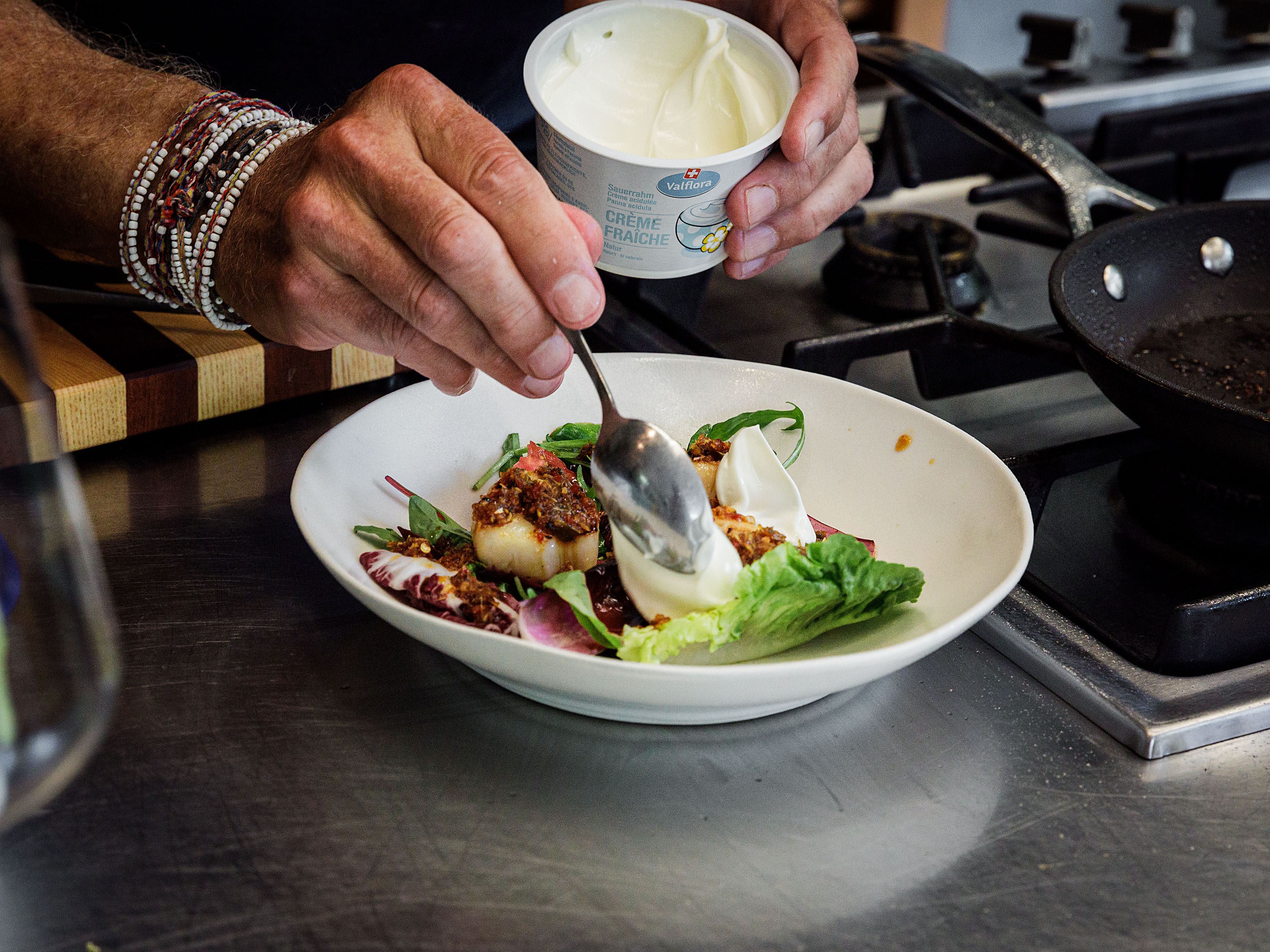 Schritt 3: Etwas Crème fraîche über das Muschelfleisch löffeln und grosszügig mit Chilisauce beträufeln